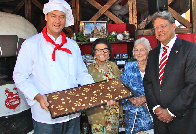 Dr. Markus Söder (l.), Henriette Schmidt-Burkhardt (2.v.l.) mit Freundin Marianne Friedlein und Lebkuchen Schmidt-Geschäftsführer Thomas Wrede präsentieren einen frisch gebackenen Lebkuchen.