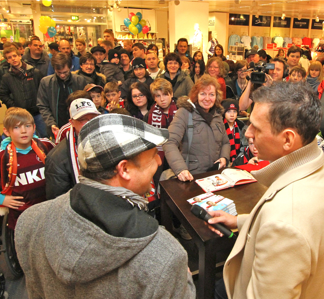 Letzten Samstag stand bei WÖHRL Erlangen ein Sportevent der Extra-Klasse auf dem Programm: Clubkapitän und Torwart Raphael Schäfer (r.) war zu Gast und signierte Autogrammkarten für große und kleine Fußballfans. Sport wird bei WÖHRL nicht nur im Sortiment groß geschrieben: Auch die aktive Sportförderung ist dem traditionsreichen Modehaus wichtig. So ist das Unternehmen seit 2012 Exklusivpartner des 1. FC Nürnberg und im Zuge dieser Kooperation bot WÖHRL seinen Kunden das besondere Event mit Raphael Schäfe