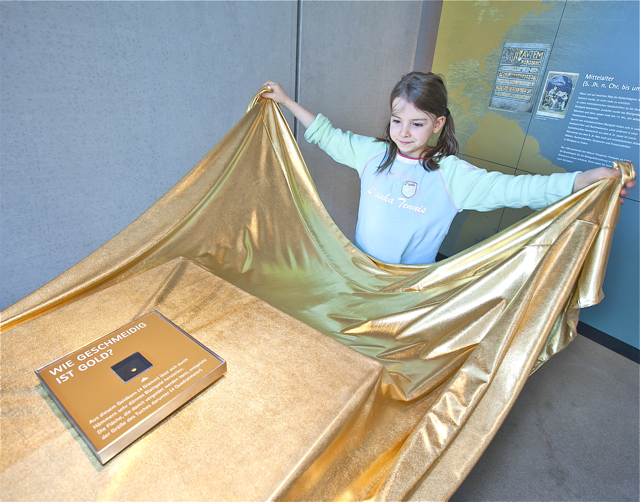 Kinder lernen im Stadtmuseum, wie welche Fläche mit Blattgold, das aus einem 4 Gramm schweren Goldkorn geschlagen wurde, vergoldet werden kann. Foto: oh / Gerhard Hagen