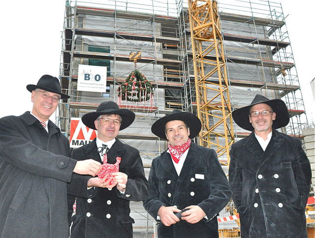 Oberbürgermeister Dr. Siegfried Balleis bedankt sich bei Wolfgang Knöpfle, Geschäftsführer der Weizenegger Objektbau GmbH, Zimmermeister Hermann Mönig und Zimmermeister Anton Rist (v.l.n.r.) für die gute Arbeit am GEWOBAU-Holzgebäude in der Isarstraße. Foto: oh