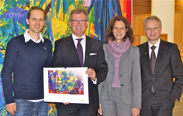 Mit dabei im Kunstkalender der Sparkasse Nürnberg 2013: Der Nürnberger Maler Philipp Findeisen (l.) mit seinem bunten Dschungelbild, gehalten vom stellv. Vorstandsvorsitzenden der Sparkasse Nürnberg Roland Burgis. Daneben: Dr. Andrea Dippel, Leiterin Kunstvilla im Kunstquartier und Sparkasse Nürnberg-Marketingdirektor Dr. Michael Kläver. Foto: oh