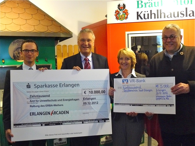 Mit einer Spendenaktion für den städtischen Umweltschutz haben die Erlangen Arcaden ihr fünfjähriges und Kitzmann-Bräu das dreihundertjährige Jubiläum ausklingen lassen. Centermanager Norman Naehrig (l.) überreichte einen Scheck über 10.000 Euro und Peter Kitzmann (r.) einen Scheck über 5.000 Euro an Umweltreferentin Marlene Wüstner (M.). Der gesamte Betrag soll der Sanierung des Erba-Weihers zugute kommen. Ursprünglich diente dieser künstlich angelegte Teich zur Kühlung der Maschinen in der Erlanger Baumw