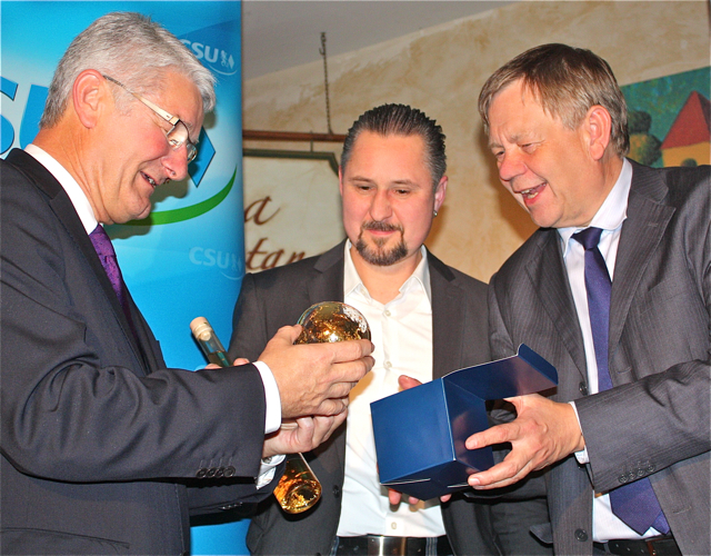 Karl Freller (r.) und der stellvertretende Kreisvorsitzende Oliver Memmler überreichen Theo Zellner Goldsekt und eine Goldkugel. Foto: Schlampp