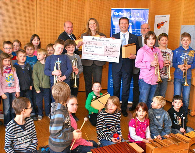 Matthias Dießl übergibt umrahmt von Kindern der Elisabeth-Krauß-Schule den Spendenscheck an Ulrike Hambitzer. Stiftungsratsmitglied Friedrich Biegel (hi.l.) und der stellvertretende Geschäftsführer der Lebenshilfe Fürth, Werner Steinkirchner (hi.r.), freuen sich ebenfalls mit den Kindern. Foto: oh