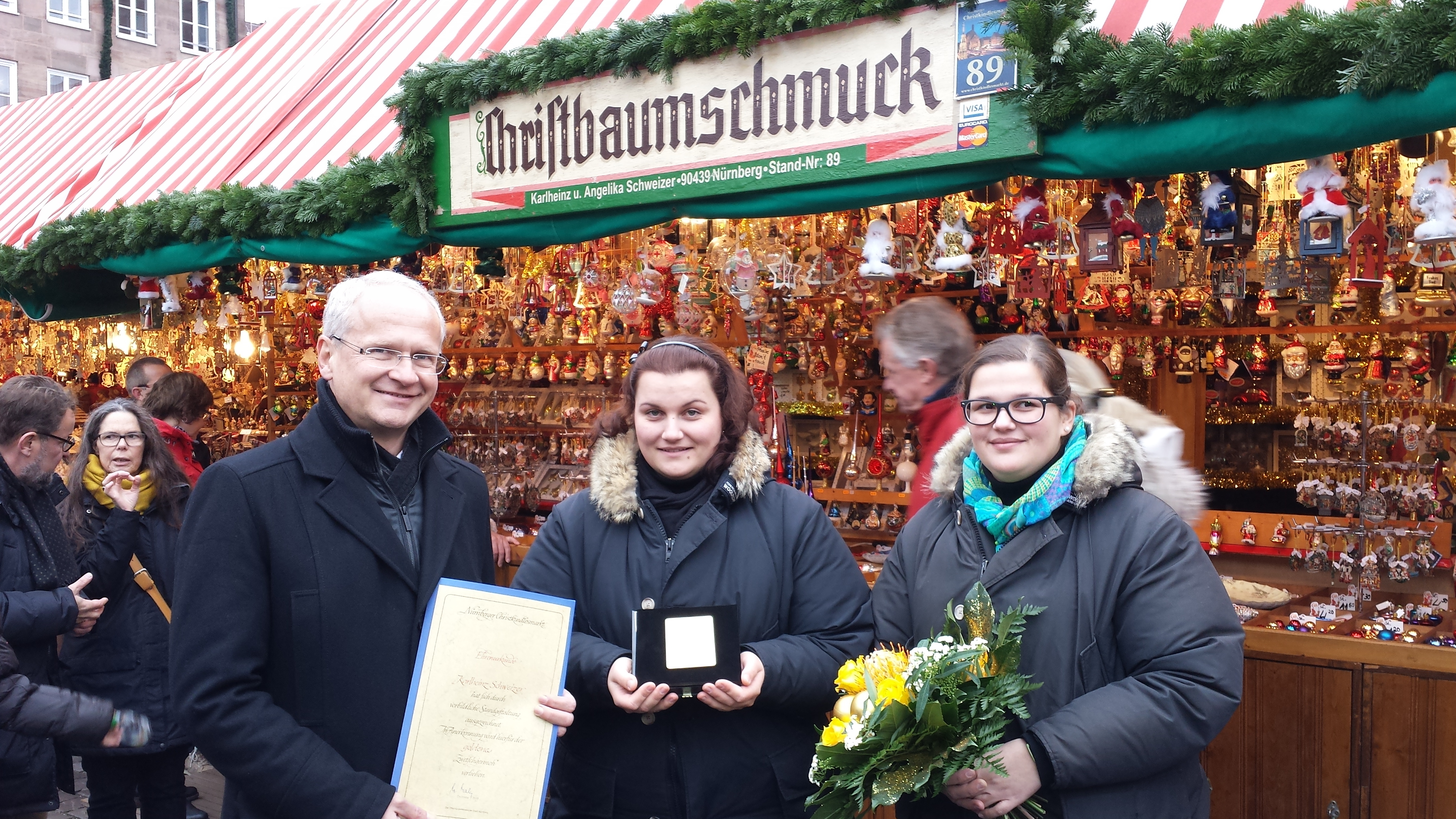 Der Goldene Zwetschgermoh - verliehen von Bürgermeister Dr. Klemens Gsell - geht heuer an Simona (r.) und Tatjana Schweizer für ihren schönen Stand mit Christbaumschmuck.