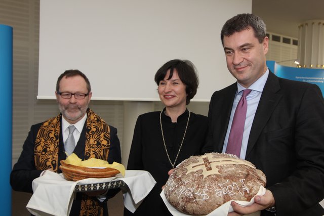 Regionalbischöfin Hann von Weyhern und Dekan Hubertus Förster übergeben Salz und Brot an Dr. Markus Söder (r.). | Foto: John R. Braun