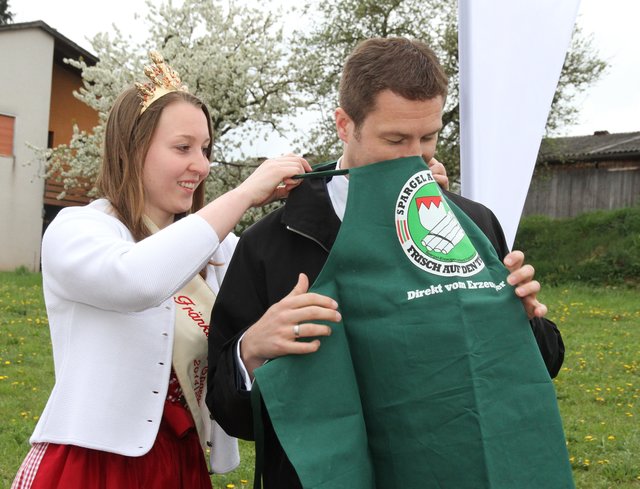 Zum Schmunzeln: Spargelkönigin Miriam Adel zieht Landrat Matthias Dießl eine Spargelschürze an. | Foto: bayernpress