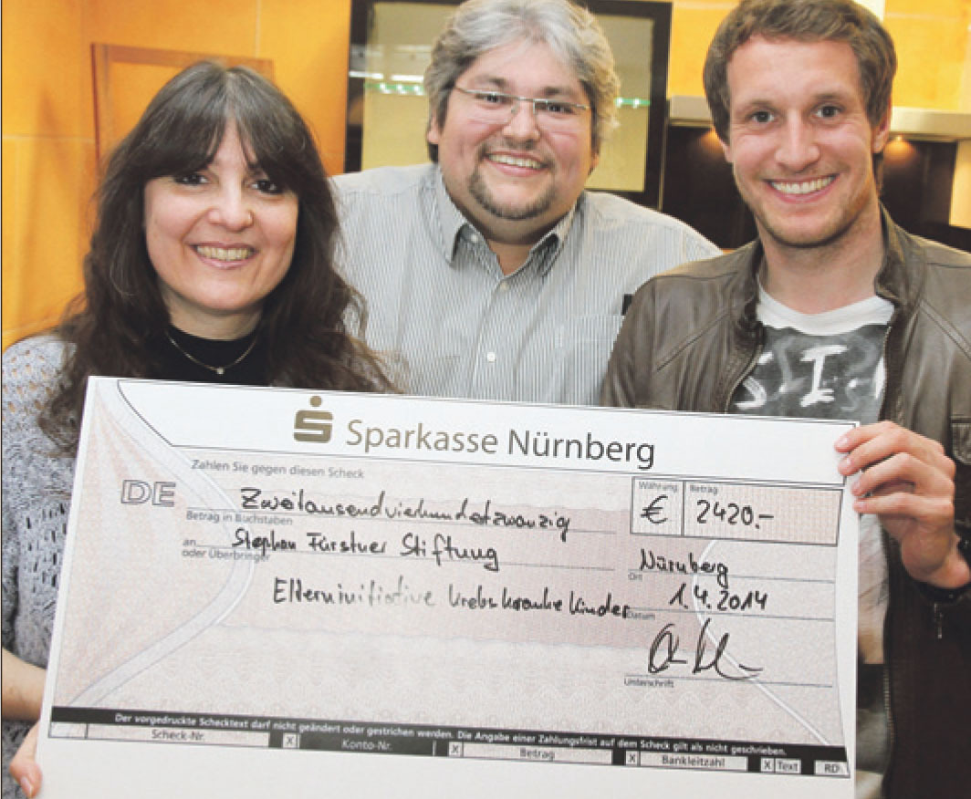 Omar und Daniela Mahroum präsentieren zusammen mit Stephan Förster (r.) den Spendenscheck