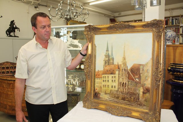 Jörg Steffen Meister mit einem historischen Ölgemälde, das den schönen Brunnen am Nürnberger Hauptmarkt zeigt. Leider gibt es viele ähnlicher Motive, was den Wert stark nach unten drückt. | Foto: Victor Schlampp