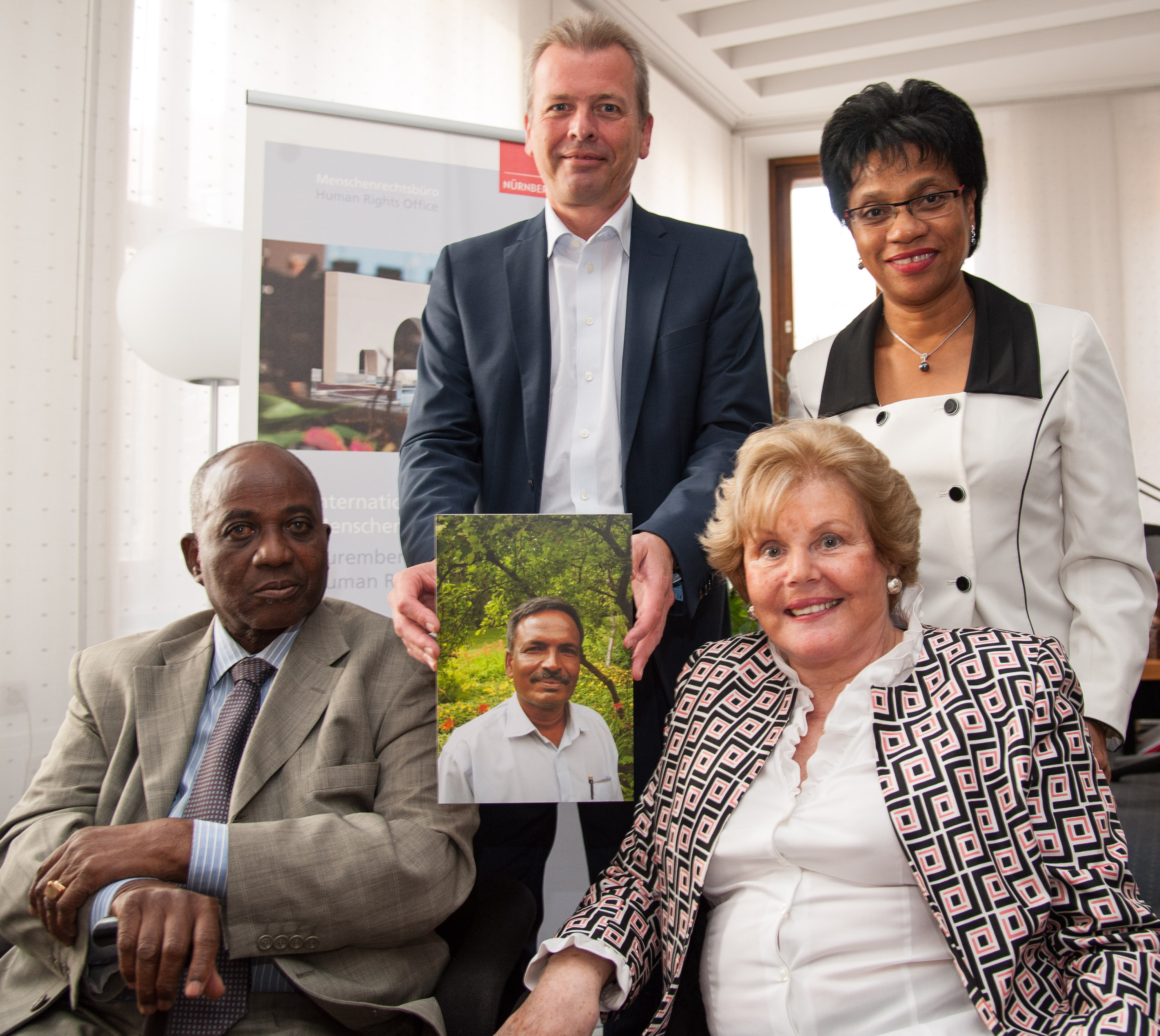 Bekanntgabe des Trägers des Internationalen Nürnberger Menschenrechtspreises 2015: Oberbürgermeister Dr. Ulrich Maly (hinten links) präsentiert ein Foto des Preisträgers Amirul Haque Amin gemeinsam mit den Jury-Mitgliedern (von hinten rechts im Uhrzeigersinn) Angela Melo, Dr. Sonia Picado und Prof. Dr. Maurice Glèlè-Ahanhanzo.