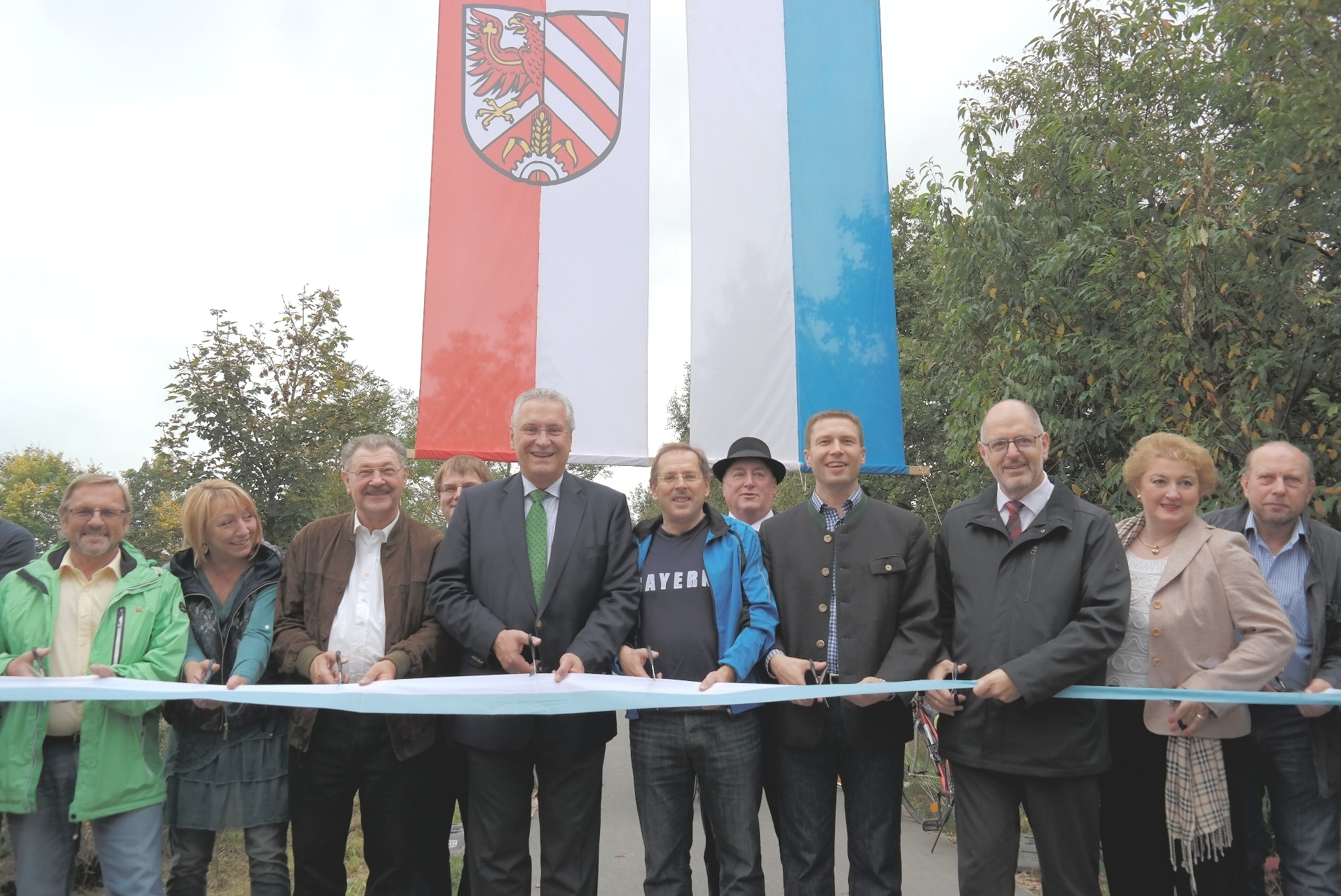 Zusammen mit Innenminster Joachim Herrmann (4.v.li.) durchschnitten Politiker und Vertreter der Landkreisgemeinden das Band zur offiziellen Freigabe des Biberttal-Radwanderweges. Foto: oh