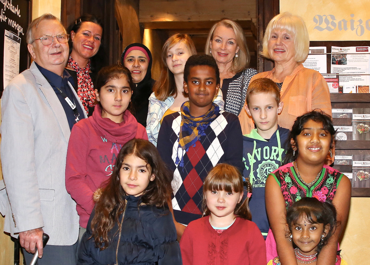„Wings to school“-Gründer Gerhard Friedrichs (l.), Helferin Dorle Fischer (2.v.l.), Verleger-Gattin Ursula Oschmann (hinten / 2.v.r.) und Betreuerin Renate Hanisch (hinten r.) begrüßten Kinder aus vielen Nationen zum beliebten Jahrestreffen im Bratwurst Röslein. Foto: MüllerVerlag