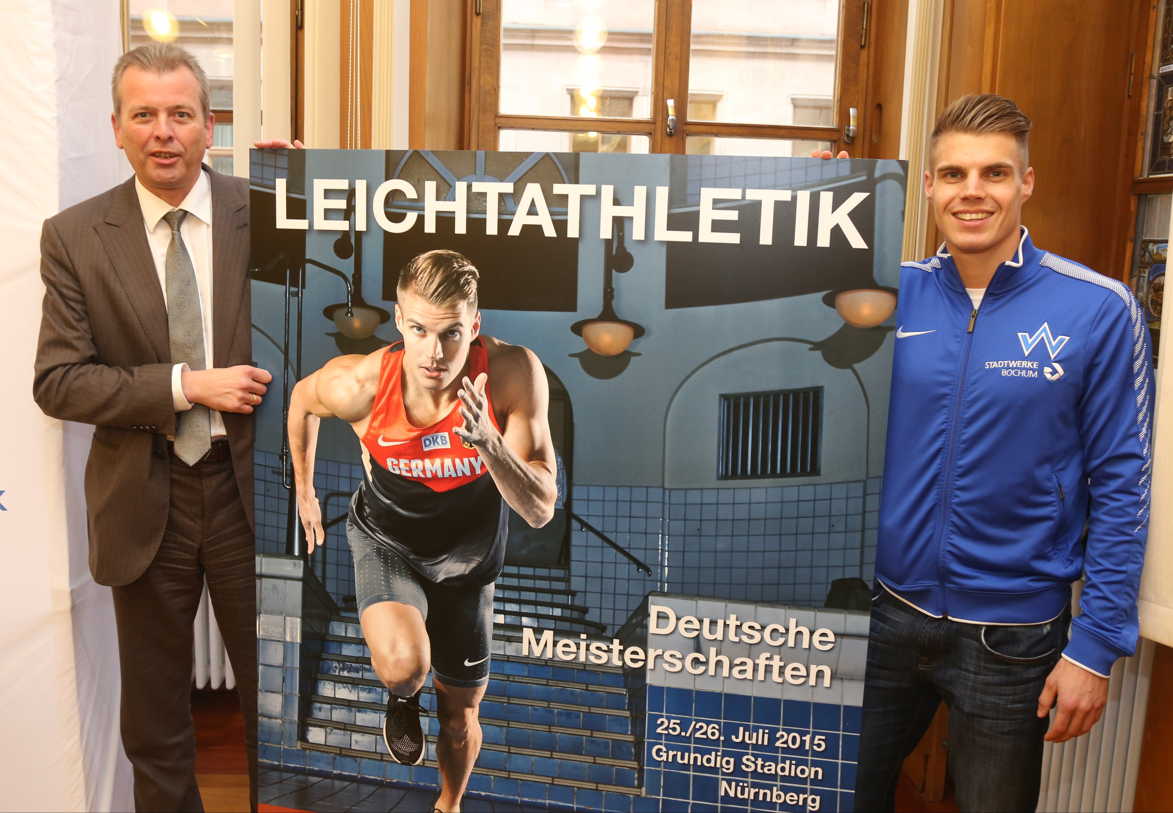 Dr. Ulrich Maly (l.), Nürnbergs Oberbürgermeister, und Julian Reus (TV Wattenscheid), Deutscher Meister/Rekordhalter im 100m-Lauf, präsentieren das neue DM-Plakat.