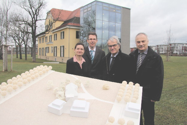 Kanzlerin Sabine König, Professor Jürgen Zerth, Architekt Gerhard Guggenberger und Stadtbaurat Joachim Krauße (v. li.n.re.) präsentieren vor dem Hochschulgebäude im Südstadtpark das Modell mit den beiden Anbauten links und rechts der gläsernen Aula (im Vordergrund).