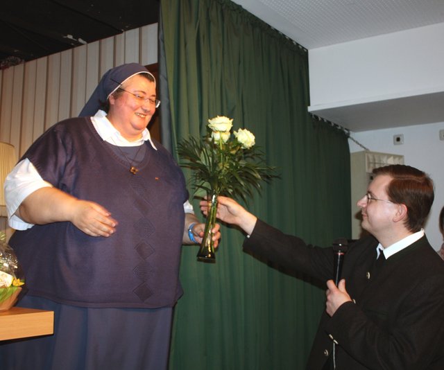 Pfarrer Tobias Scholz überreicht Schwester Theresa Zukic drei weiße Rosen, die erklärten Lieblingsblumen der erfolgreichen Ordensfrau. | Foto: Victor Schlampp