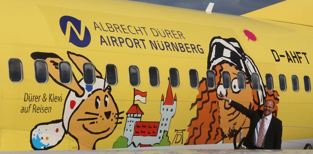 Bürgermeister Christian Vogel zeigt das neue Design der TUIfly Maschine vor - ein bunter, sympathischer Markenbotschafter für Nürnberg.