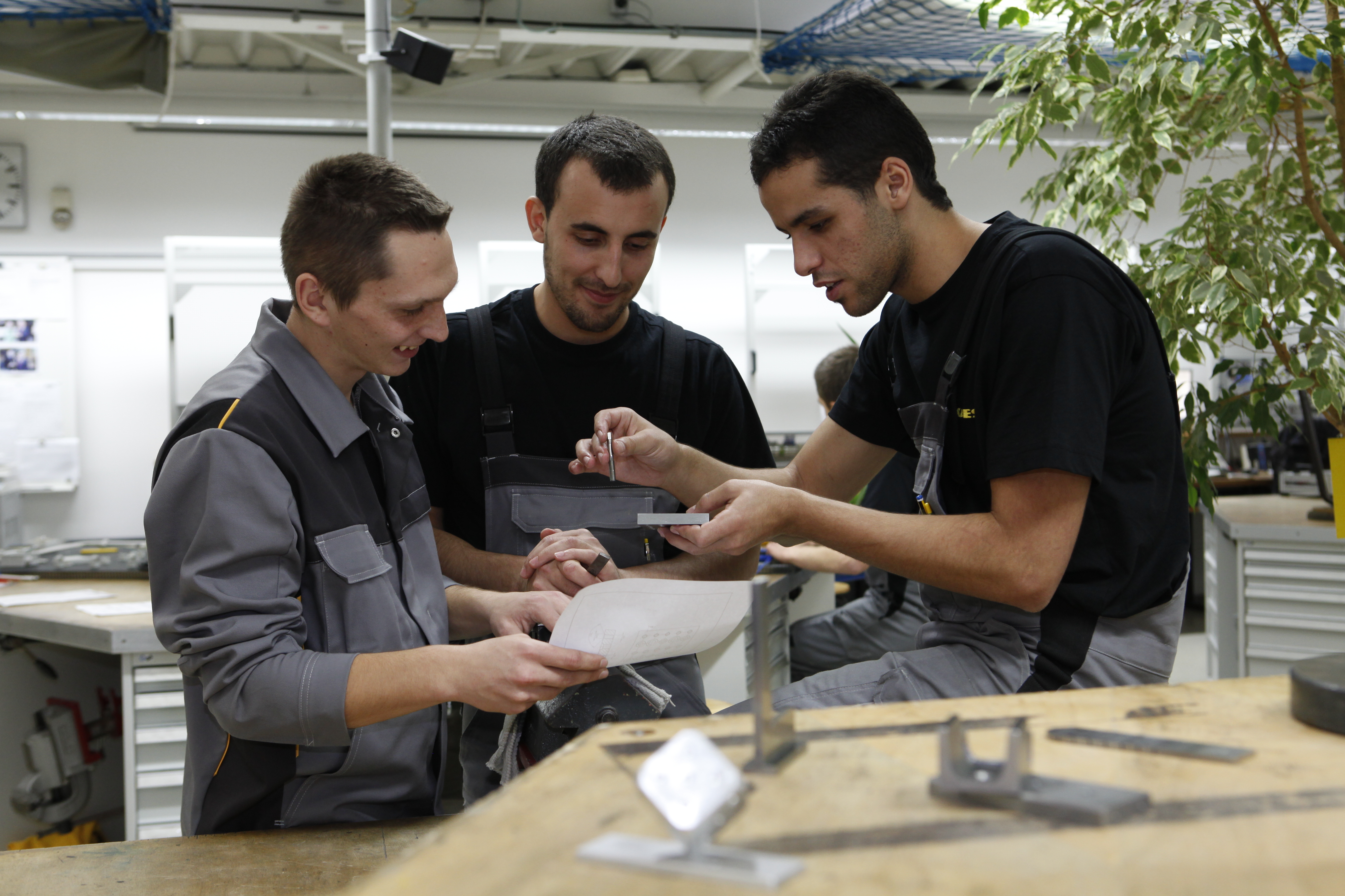 Cosmin-Vasil Enutá (Rumänien), Mohamed Layachi, Nabil Ammouzigh (beide Spanien) im Ausbildungszentrum Elektro von Kaeser Kompressoren.