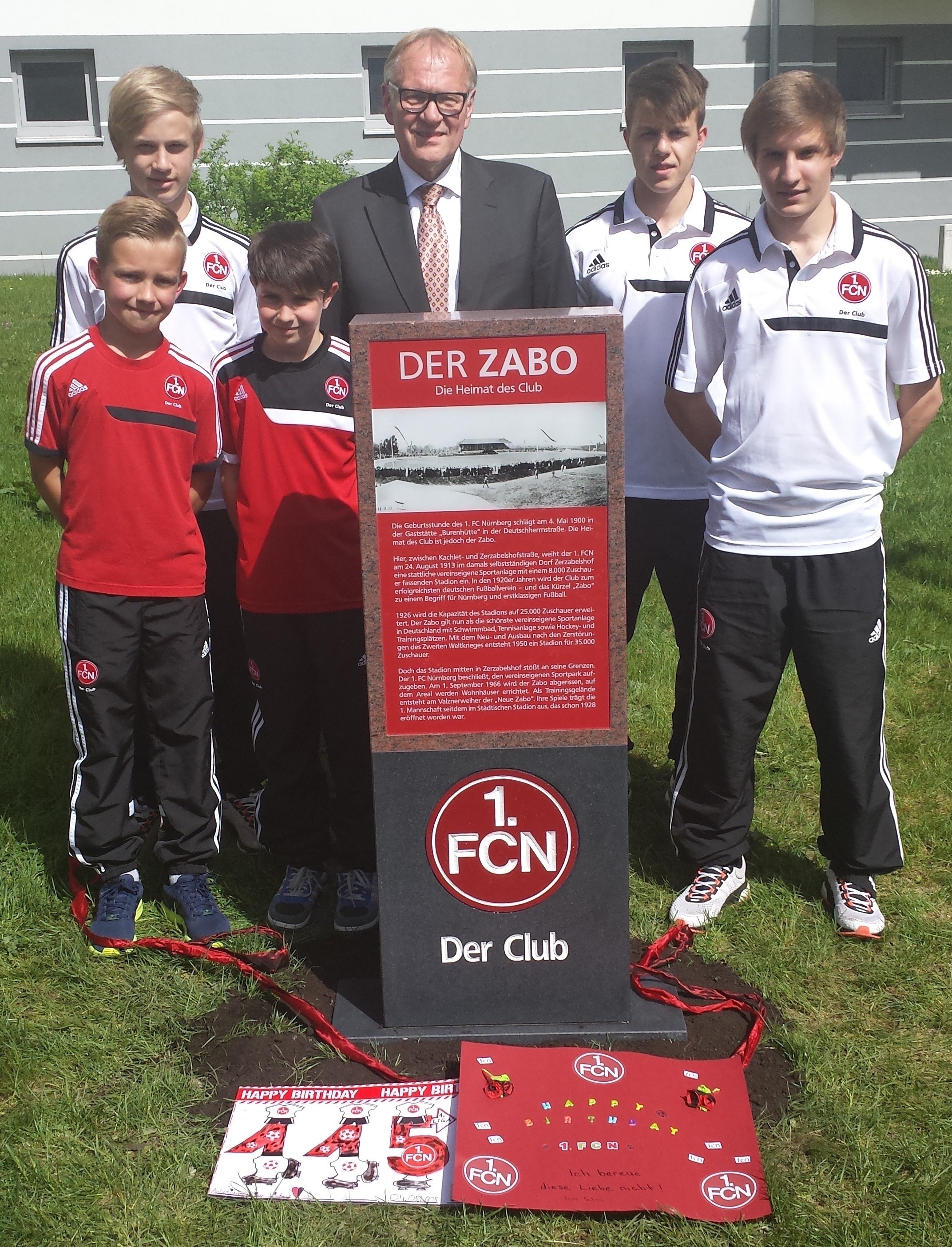 115 Jahre Club: Dr. Thomas Grethlein, Aufsichtsratsvorsitzender des 1. FC Nürnberg, Jugendspieler des NachwuchsLeistungsZentrum (NLZ) und die MINI CLUBERER des Kids Club des 1. FC Nürnberg bei der Enthüllung des Gedenksteins.
