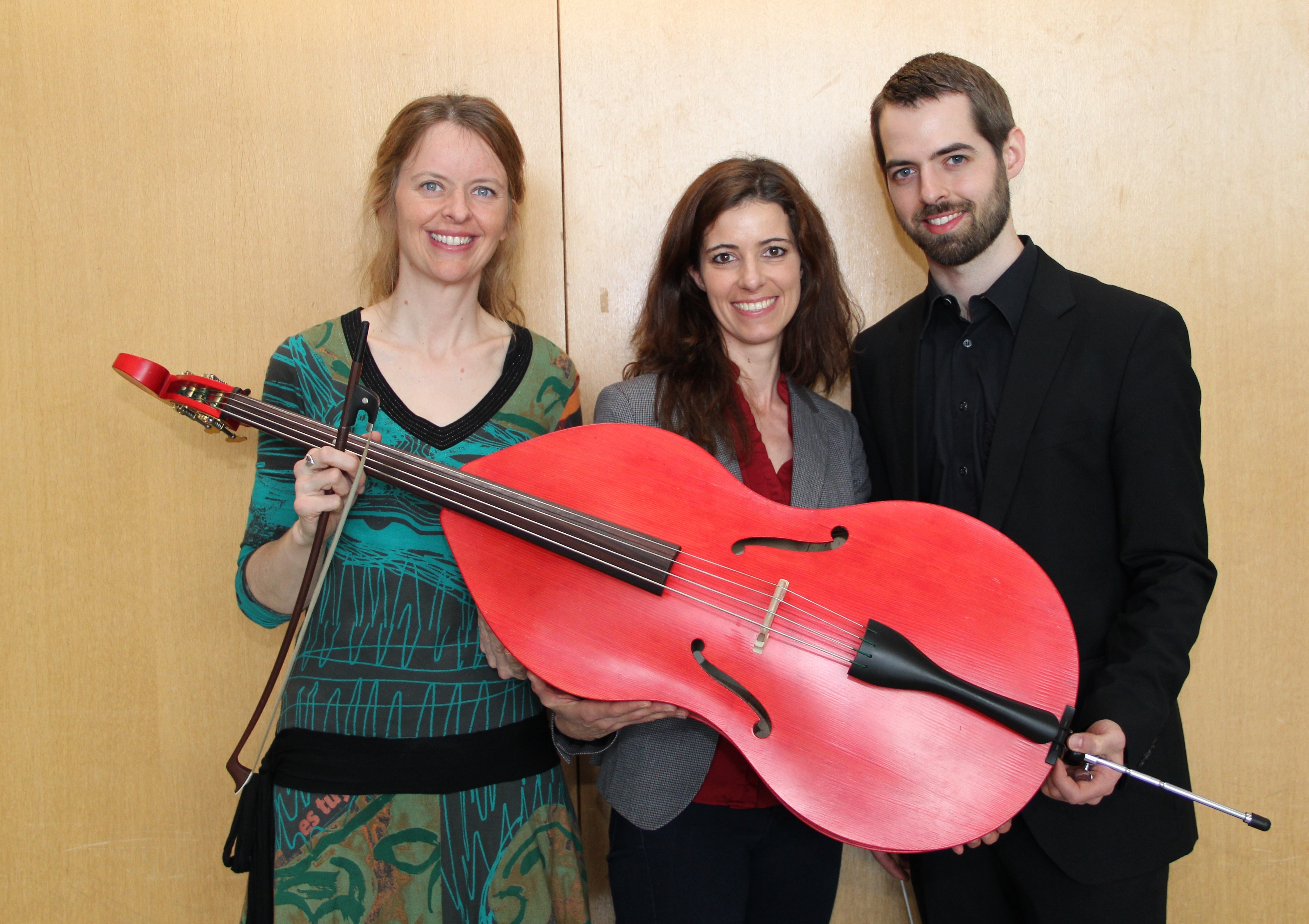 Gemeinsam am roten Kinderkontrabass (v.l.): Martina Zimmermann, die das Konzertprojekt moderierte, Marlies Gräbner aus der Unternehmenskommunikation der Sparkasse Nürnberg und John Lidfors, Vorsitzender und Dirigent des Orchester Ventuno.