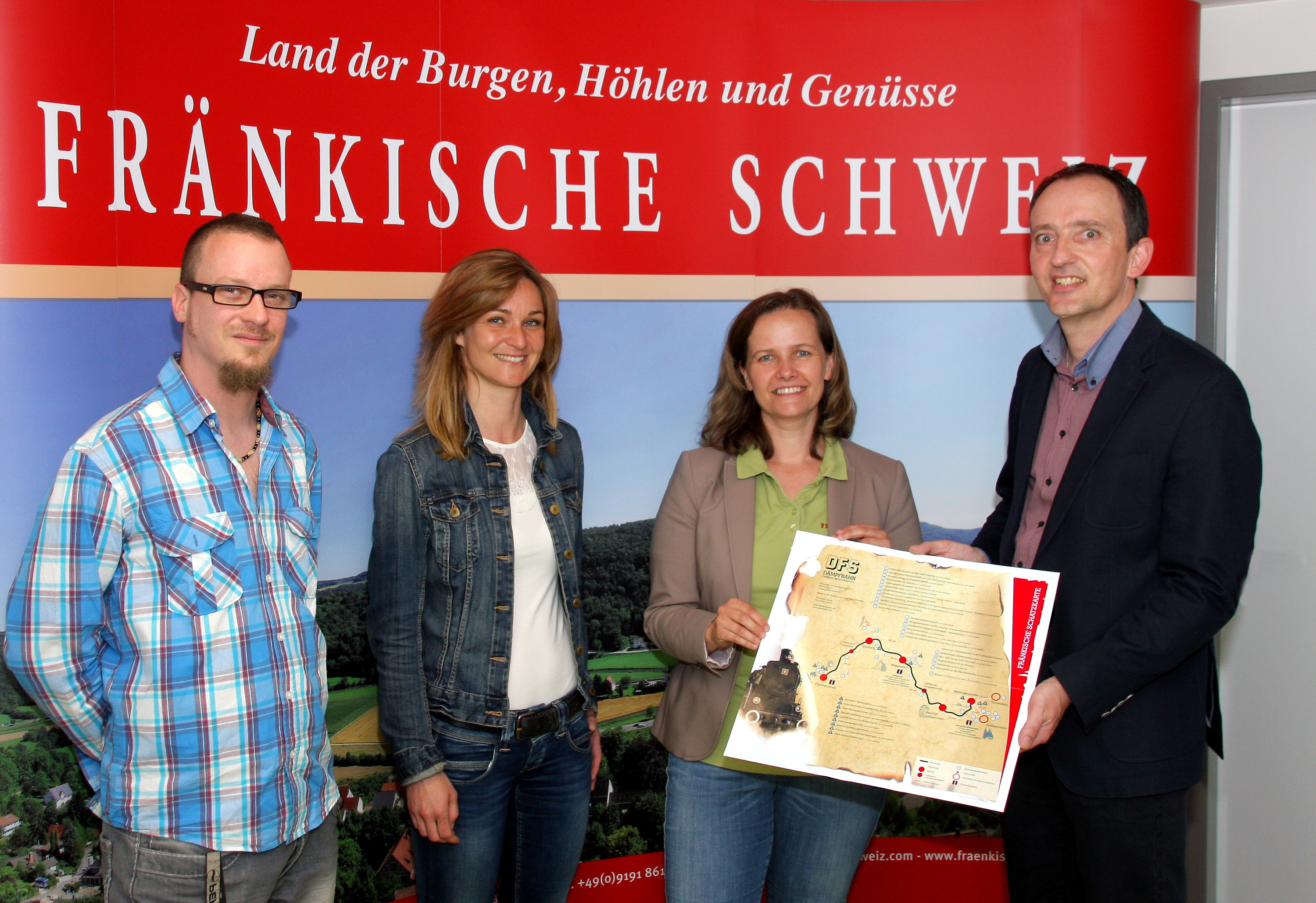 Aus den Händen des Dampfbahn-Pressesprechers Stephan Schäff erhielt Sandra Schneider, Leiterin der Tourismuszentrale Fränkische Schweiz, das erste Exemplar der "Fränkischen Schatzkarte". Carola Bäumler-Kohlbauer (2. v.li.) aus der Geschäftsstelle der Dampfbahn hatte die Idee dazu geboren, die von Christian Wolf (links) gestalterisch umgesetzt wurde.