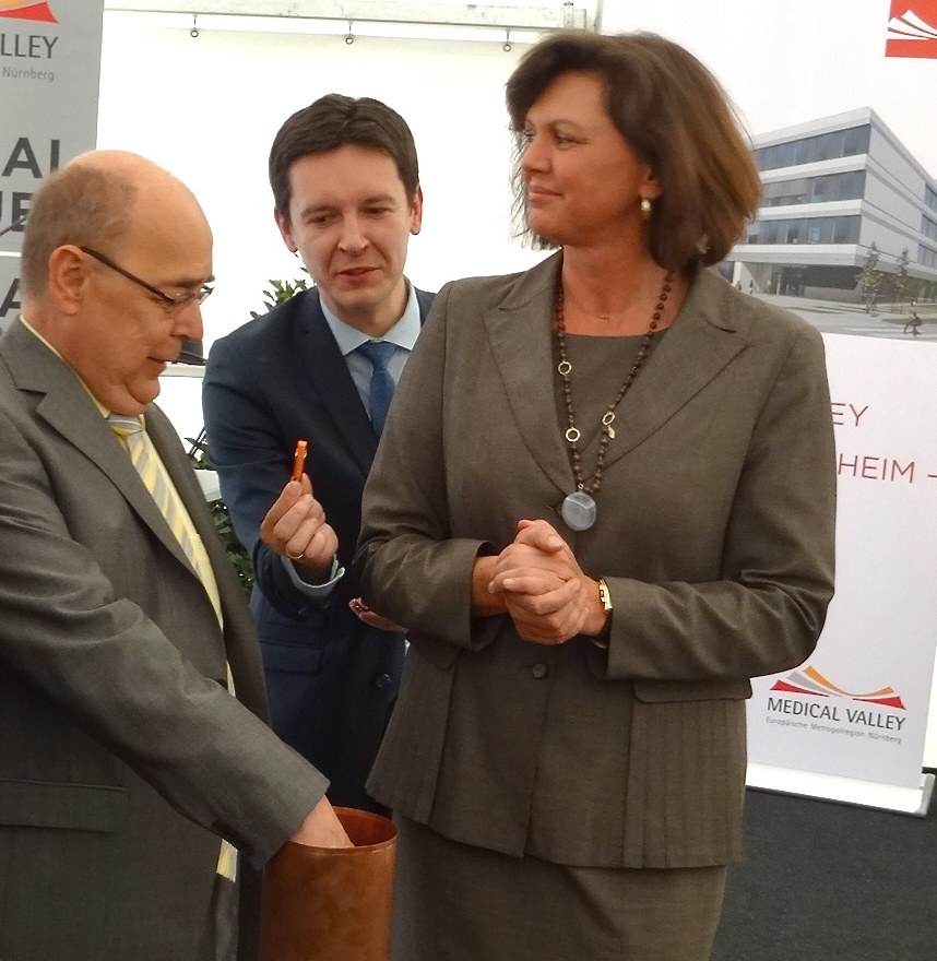 Oberbürgermeister Franz Stumpf füllt den Grundstein, neben ihm Projektleiter Viktor Naumann und Wirtschaftsministerin Ilse Aigner (v.l.n.r.). Foto: Stadt Forchheim
