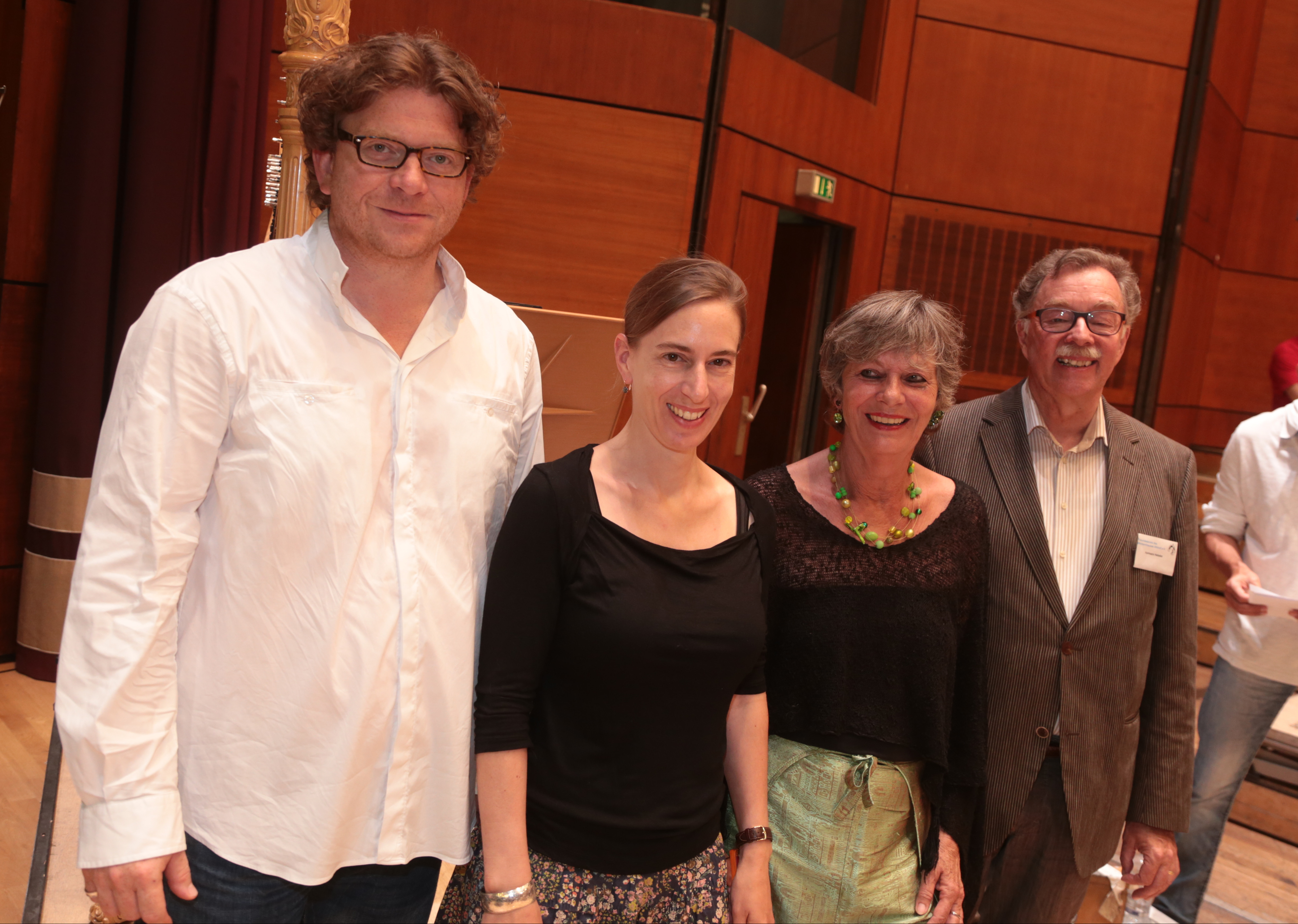 Marcus Bosch (Generalmusikdirektor Staatstheater Nürnberg), Heidi Braun (Orchestervorstand), Ulrike Voß (Flüchtlingshilfe Nürnberg e.V.) und Hermann Hebeler (Freundeskreis des Wichernhauses Altdorf e.V.) bei der Spendenübergabe in der Meistersingerhalle im Rahmen der Generalprobe des 7. Philharmonischen Konzerts (v.l.).