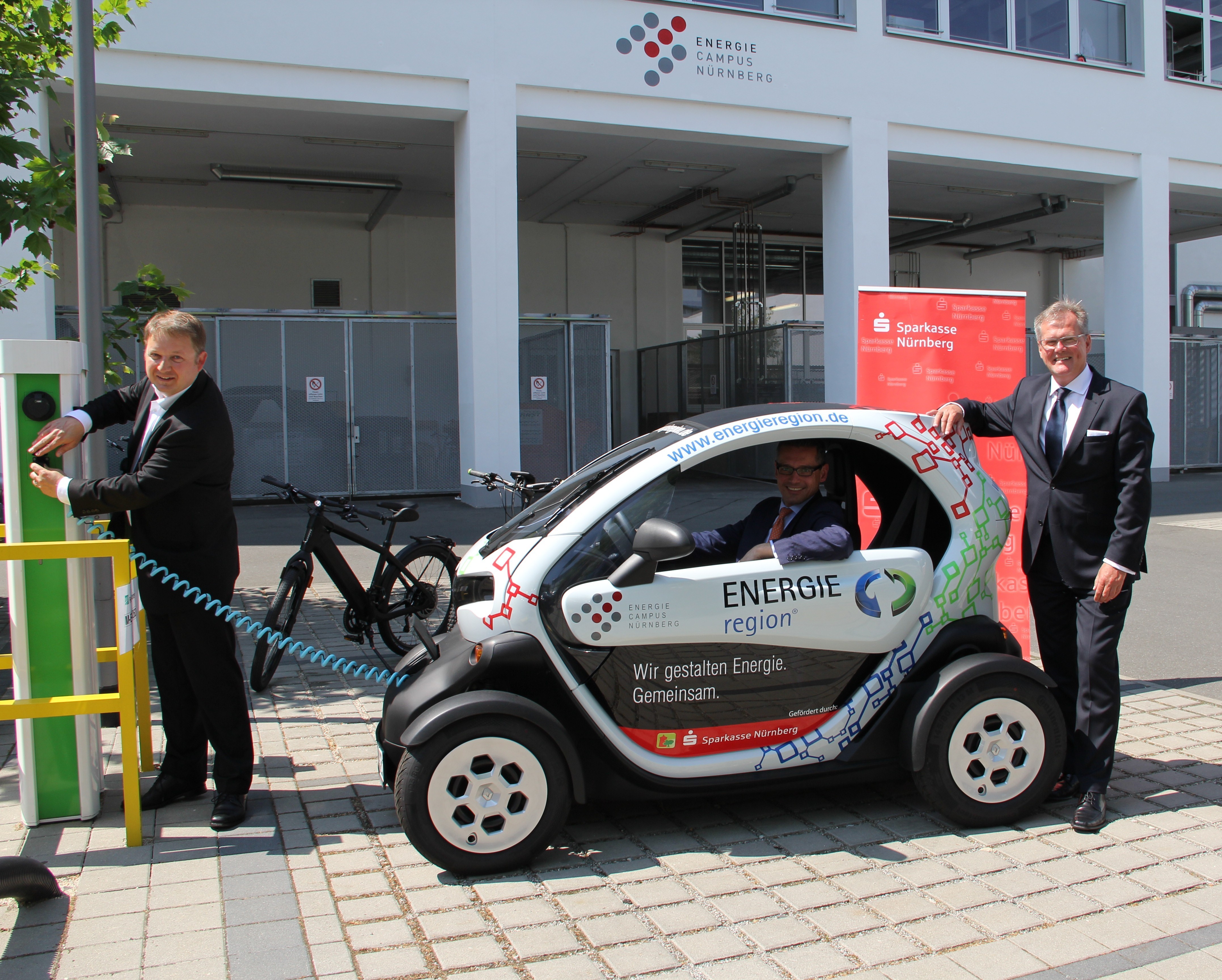 Am Freitag, 12. Juni 2015, wurde das Twizy-Elektro- Dienstfahrzeug der ENERGIEregion im Beisein von Roland Burgis (r.), stellvertretender Vorstandsvorsitzender der Sparkasse Nürnberg, Dr. Michael Fraas (im Auto), Wirtschaftsreferent der Stadt Nürnberg und Vorsitzender der Kompetenzinitiative ENERGIEregion Nürnberg e.V. sowie Dr. Jens Hauch (l.) Geschäftsführendes Vorstandsmitglied ENERGIEregion Nürnberg, offiziell in Betrieb gestellt.