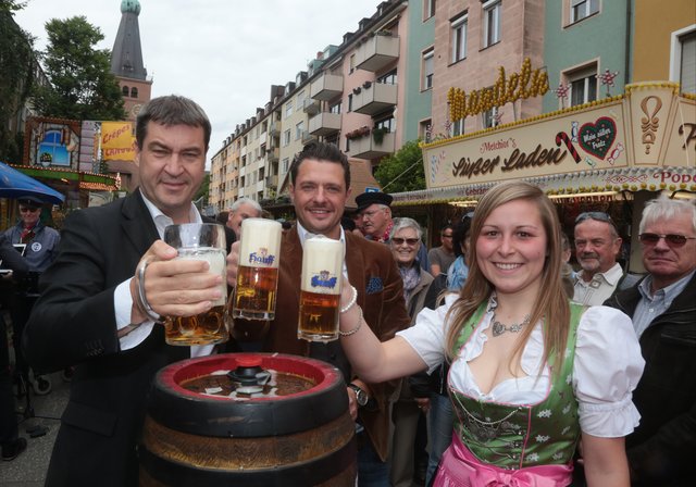 Dr. Markus Söder mit Assistentin Cristin Gundel, Junior-Chefin der Hauff-Brauerei, stoßen auf die Eröffnung der Johannis Kirchweih an - in der Mitte: Festwirt Tobias Teichmann. | Foto: bayernpress