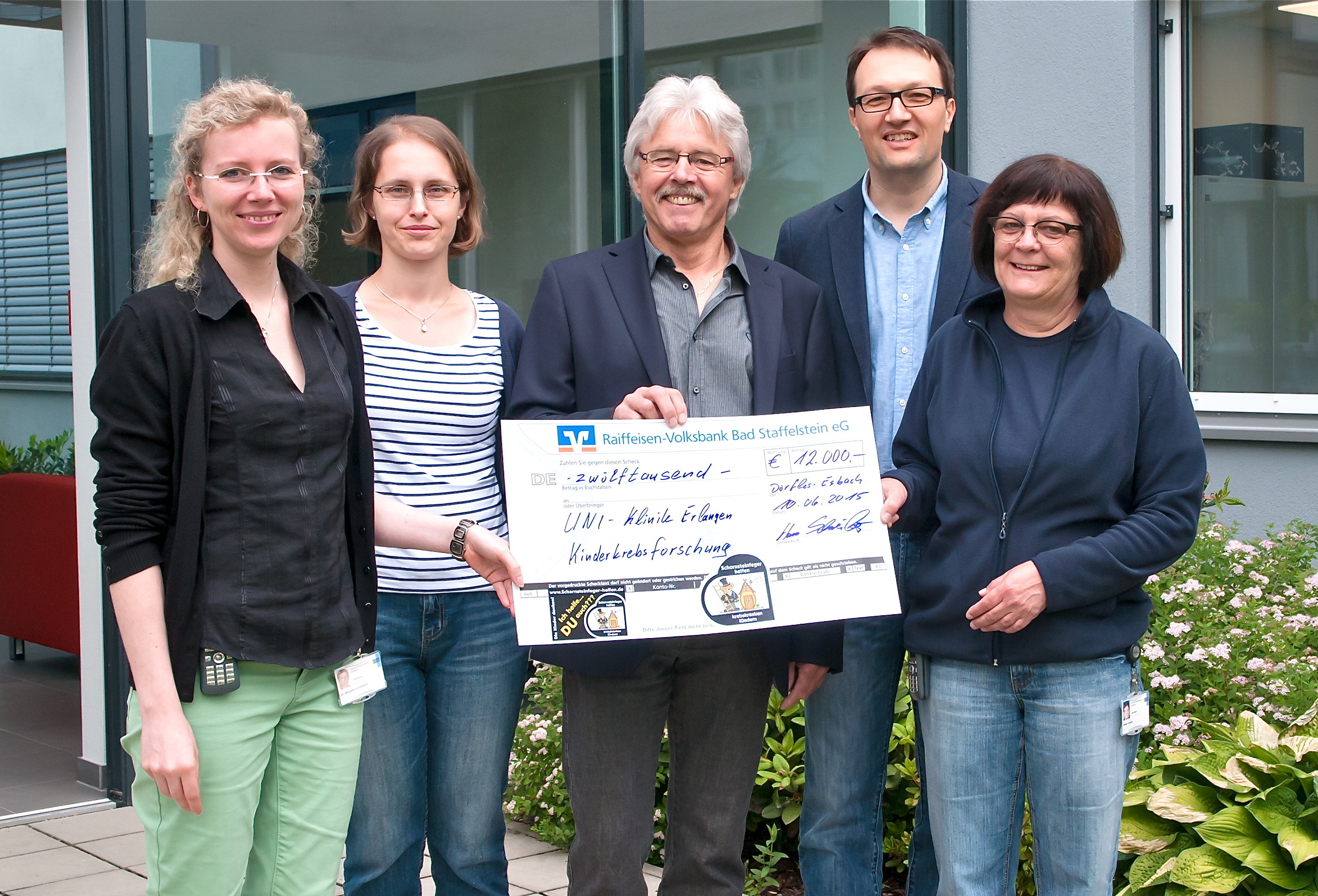 Scheckübergabe vor den modernen Forschungslabors der Arbeitsgruppe Pädiatrische Onkologie: Dr. Manuela Krumbholz (Biologin), Sabine Semper (MTA), Hans Schreiber (Vorsitzender Verein Schornsteinfeger helfen krebskranken Kindern), Prof. Dr. Markus Metzler (Leiter des Bereichs Onkologie und Hämatologie) und Ursula Jacobs (MTA / v.l.n.r.). Foto: Uni-Klinikum Erlangen