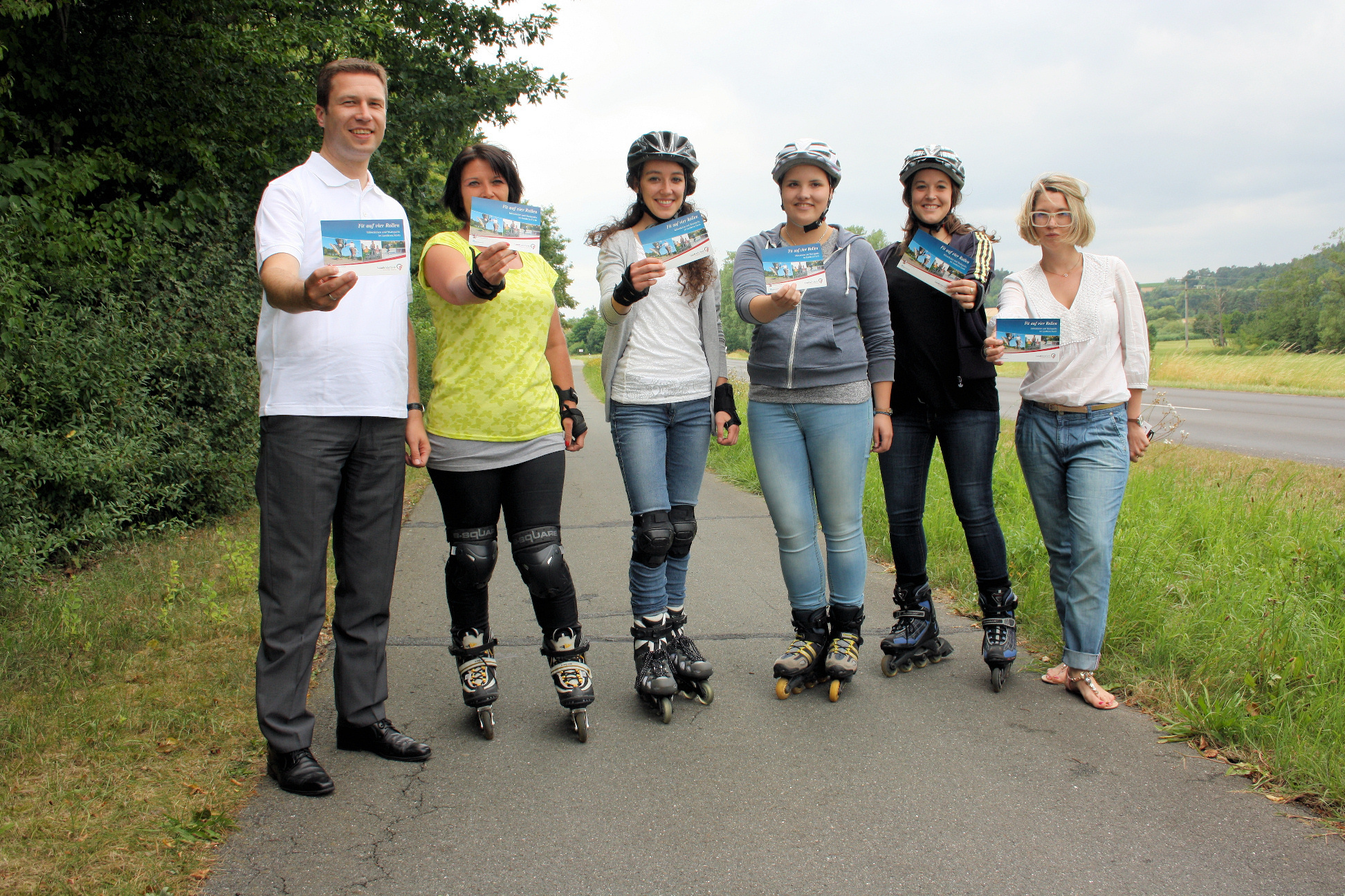 Zusammenmit vier begeisterten Damen auf ihren Inline-Skatern präsentieren Landrat Matthias Dießl (li.) und Joanna Bacik (re.) den Flyer, auf dem die Strecken verzeichnet sind.