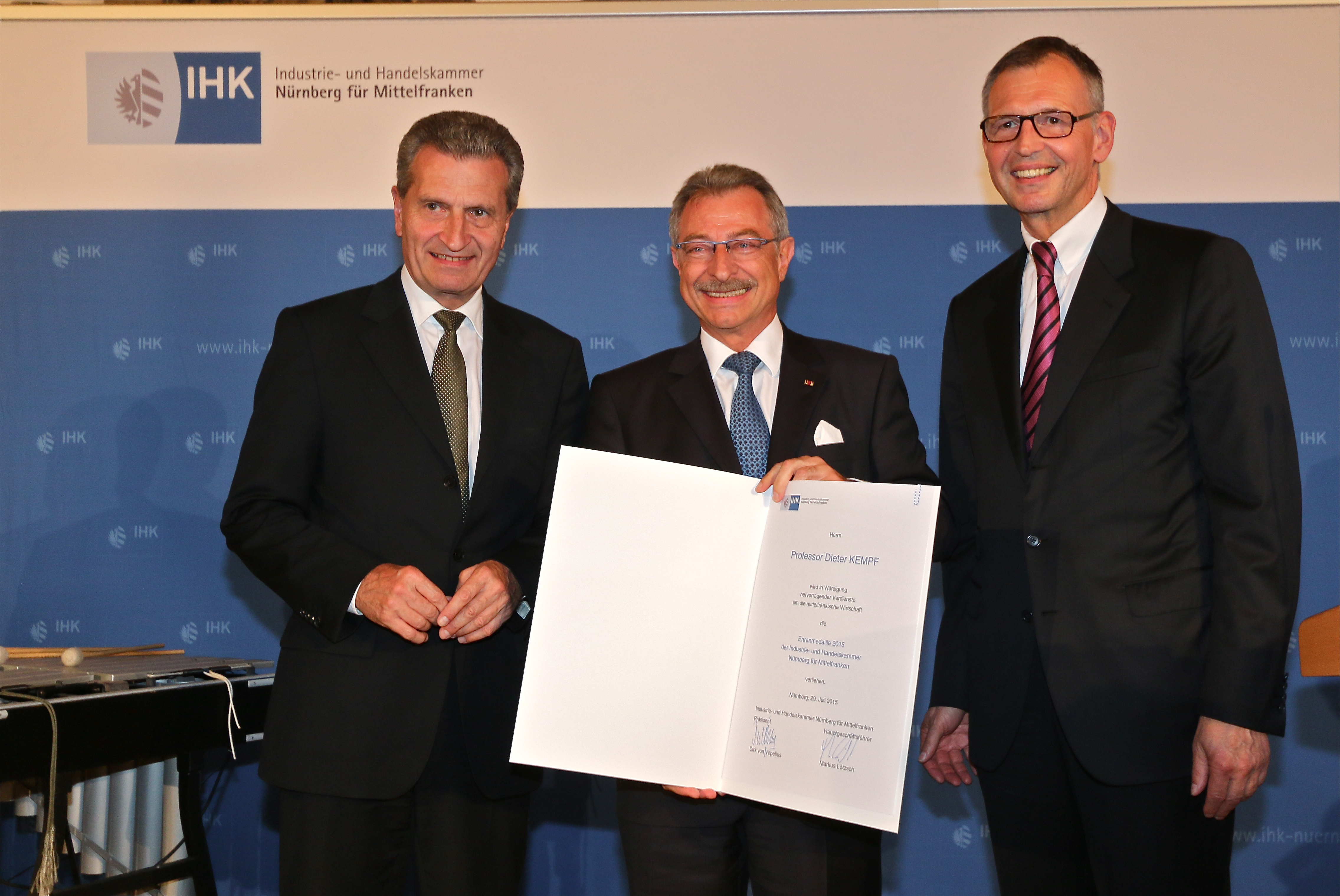 Prof. Dieter Kempf (M.), EU-Kommissar Günther Oettinger (l.) und IHK-Präsident Dirk von Vopelius (r.) mit der Ehrenurkunde. Foto: John R. Braun