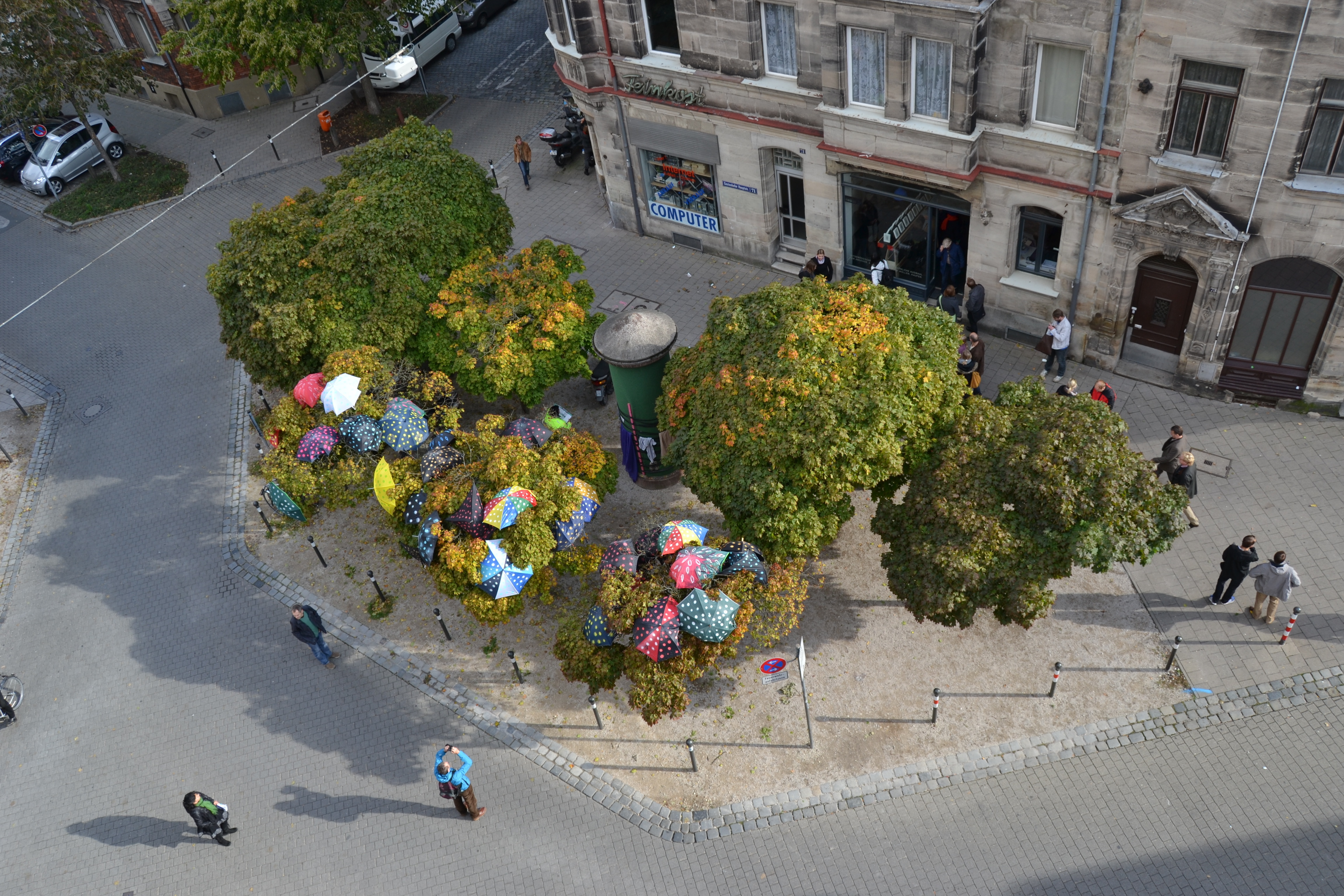 Die Bunten Schirme in den Bäumen auf dem Petra-Kelly-Platz: Installiert vom Architekturstudenten Michael Paulus. Foto: Hauke Hoffmeister, Nürnberg