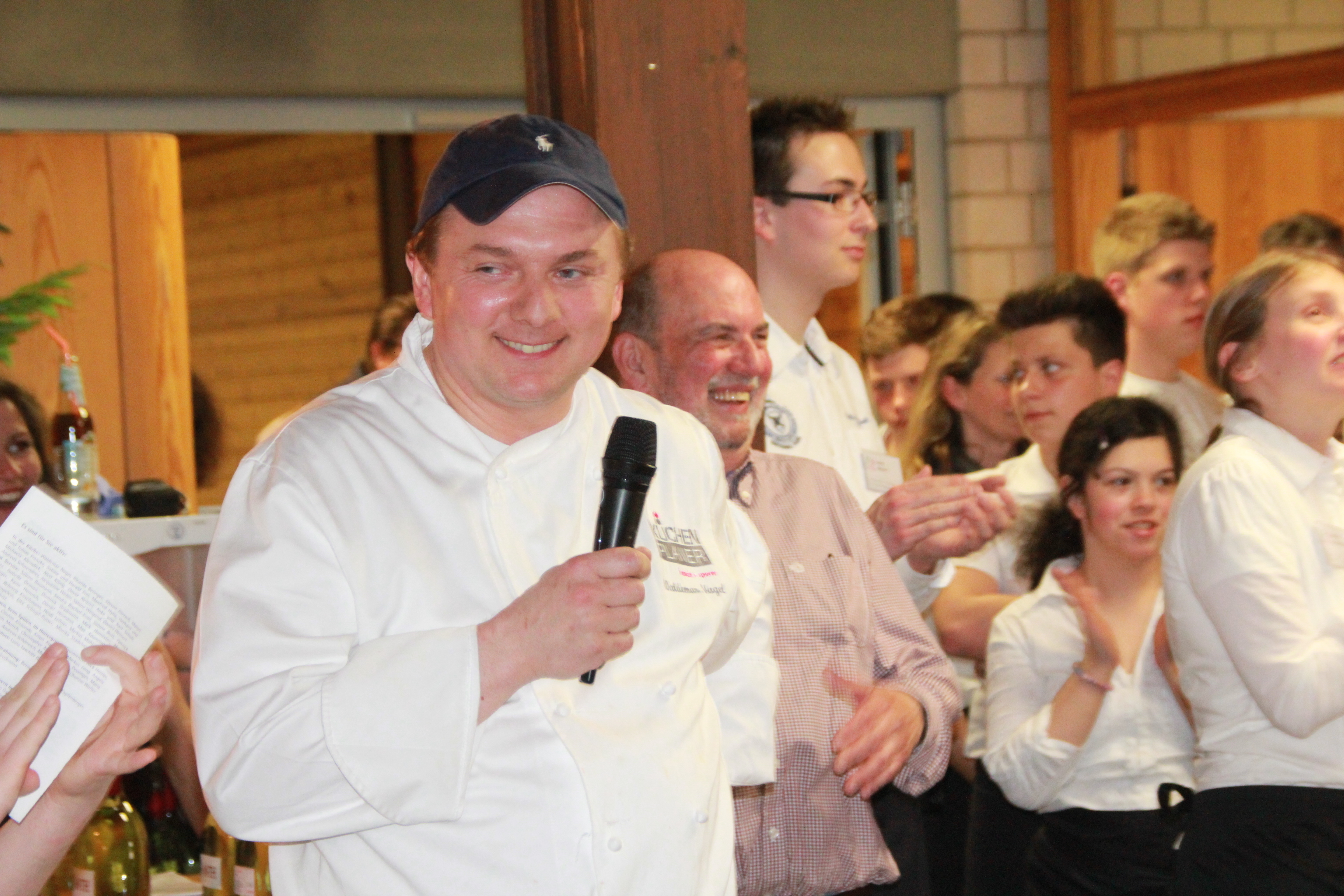 Den Gästen schmeckt es und Waldemar Nagel strahlt, denn mit dem Engagement seines Teams und der Schüler hat wieder einmal alles bestens geklappt. Selbst Jürgen Ganss (hinter Nagel stehend), der den Wein stiftete, freute sich über die positive Resonanz. Fotos: Ursula Kaiser-Biburger