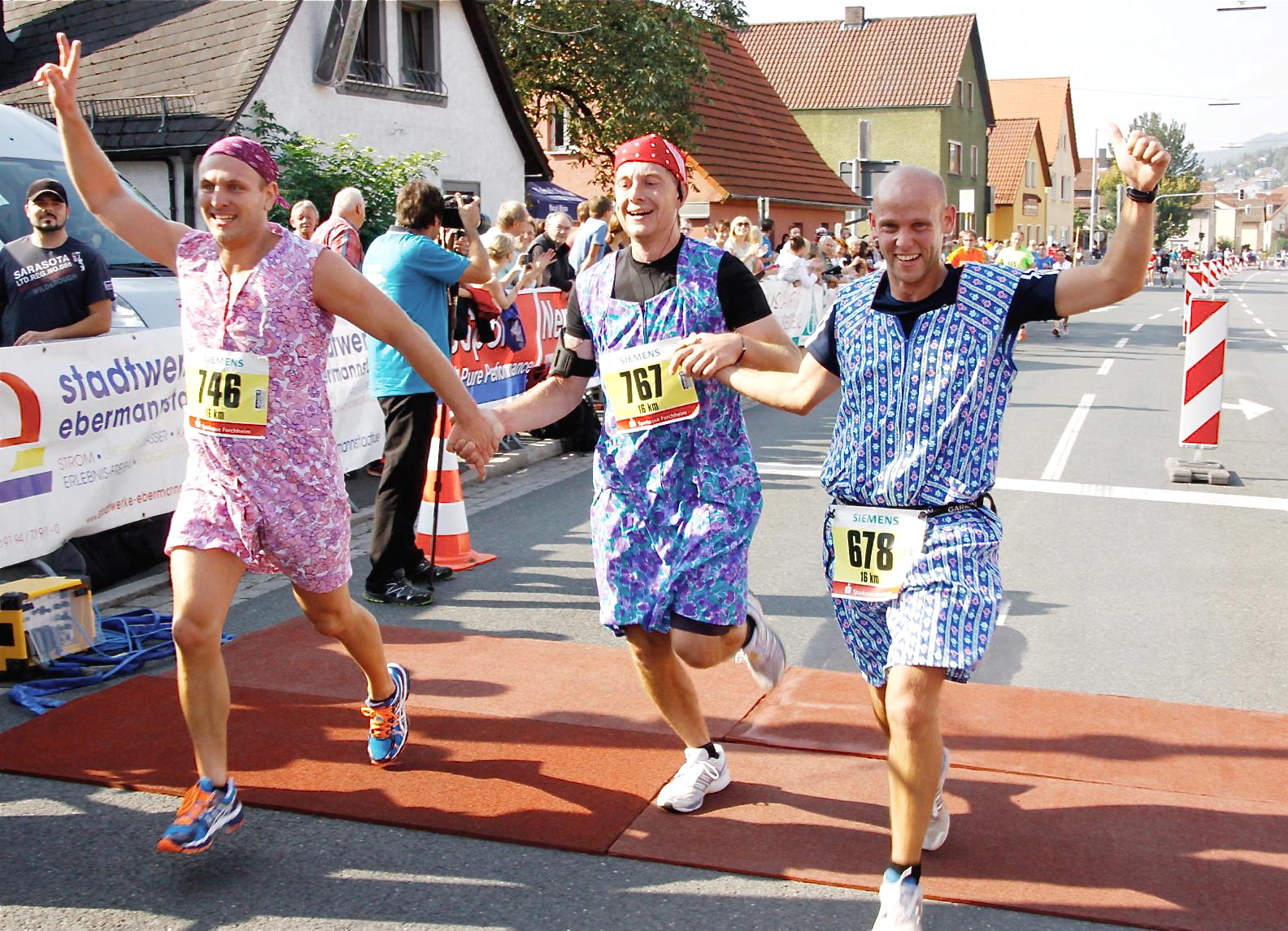 Spaßläufer mit Schürze beim Überqueren der Zeitmatte in Ebermannstadt. Sie haben gut lachen, denn sie haben die Strecke (16 km) geschafft. Foto: Loewisch