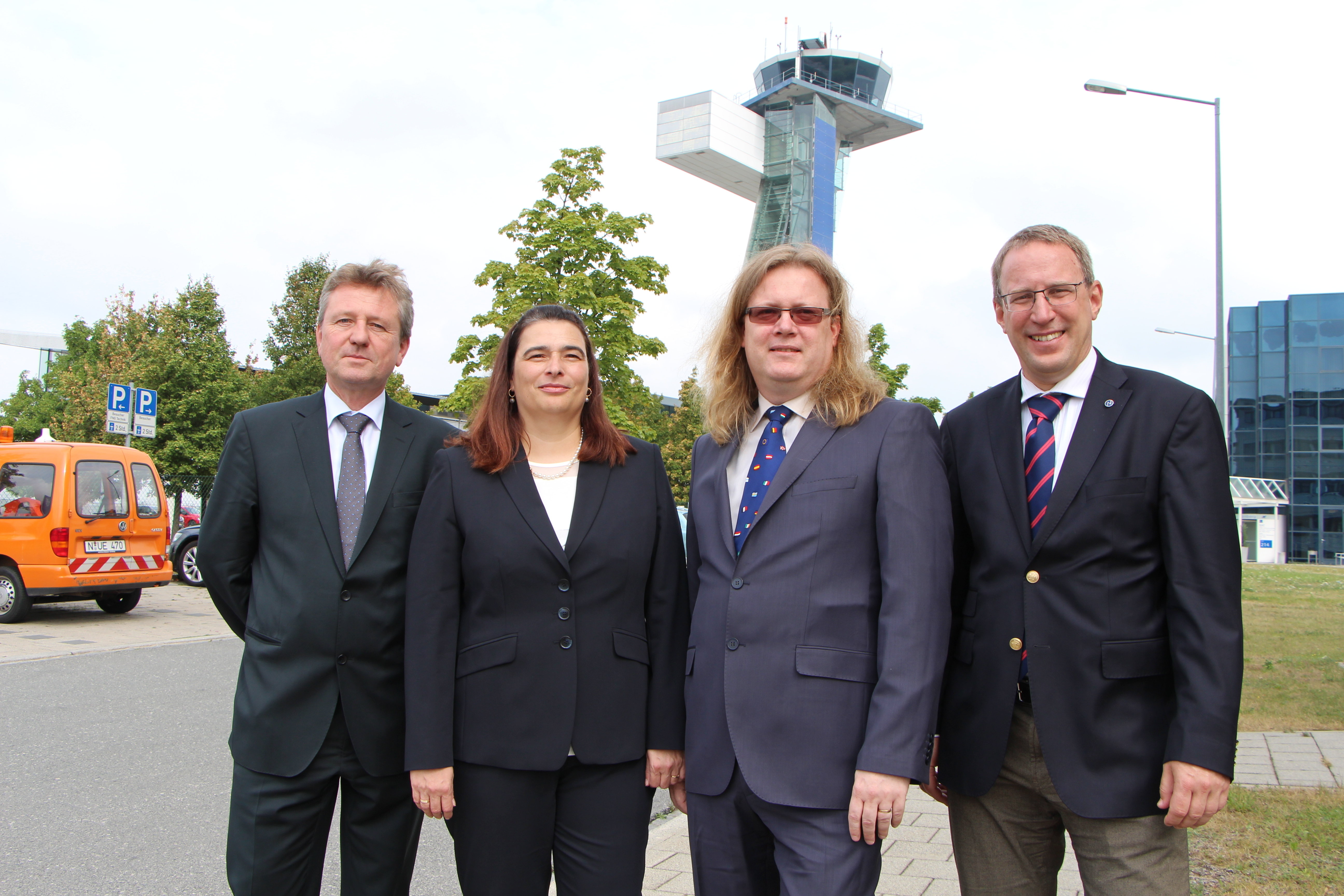 Uwe Müller, Leiter Non-Aviation des Flughafens, Elena Helwig und Martin Helwig, beide Geschäftsführer von BBCN, und Dr. Michael Hupe, Flughafengeschäftsführer. Im Hintergrund ist der Tower zu sehen.