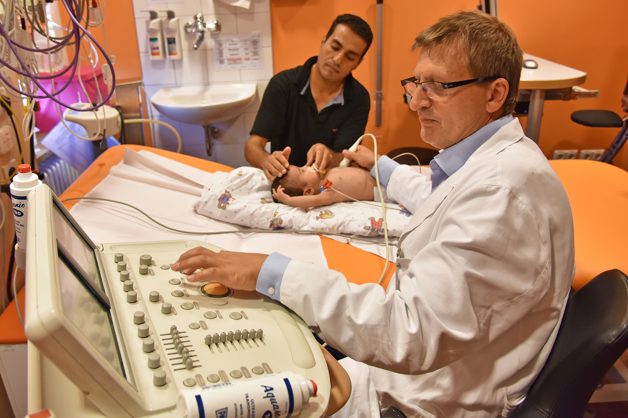 Prof. Dr. Sven Dittrich, Leiter der Kinderkardiologie des Uni-Klinikums Erlangen, untersucht die kleine Raghad, die immer Vater Ayman an ihrer Seite hat.