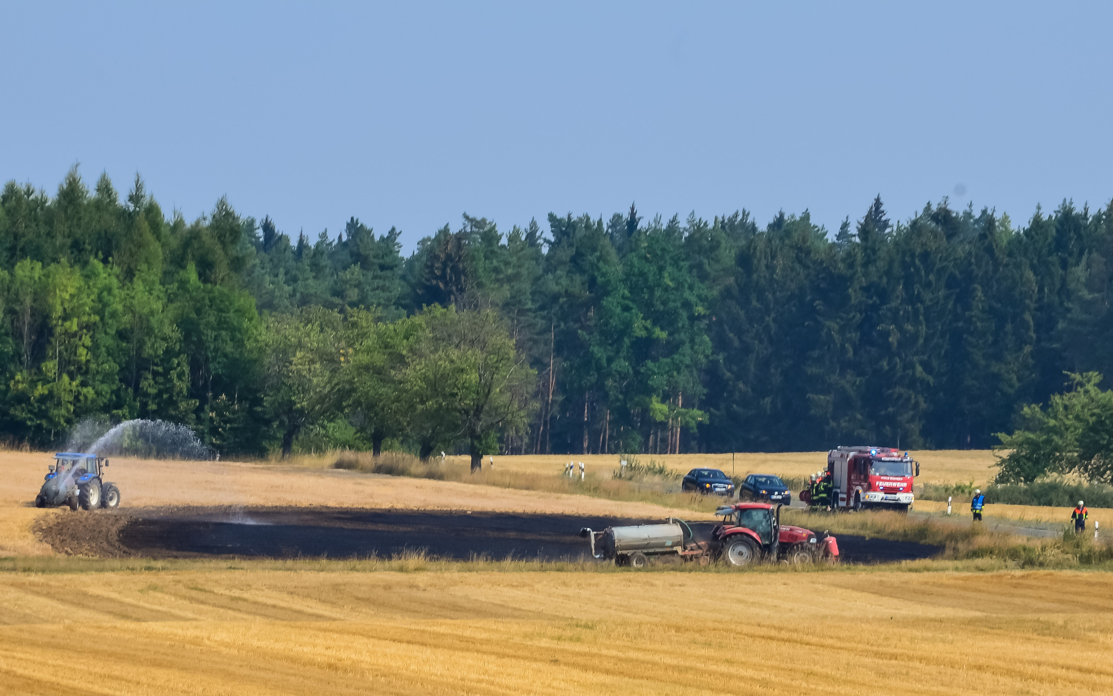 Die anhaltende Hitze und ihre Schattenseiten: Feuerwehr und Landwirte löschen einen Feldbrand zwischen Hohenpölz und Königsfeld in Oberfranken.