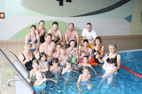 Stolz und begeistert - Kinder lernen mit ihren Eltern oder Großeltern schwimmen. Kursleiterin Annette Wolz (rechts außen) und Veranstalter Hermann Gabel (dahinter) beglückwünschen die Wasserratten.