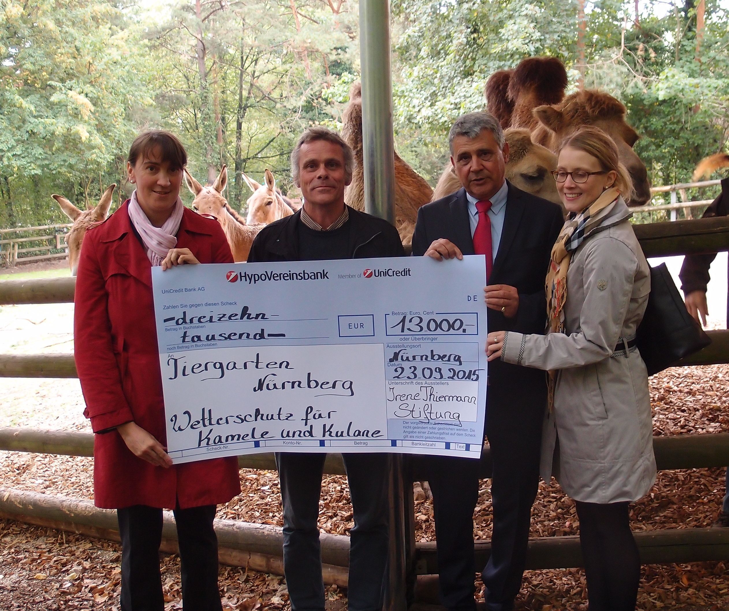 Dana Becker (l.) und Sandra Bührke (r.), beide Vorstandsmitglieder der Irene Thiermann Stiftung, überreichen Tiergartendirektor Dr. Dag Encke (2.v.l.) zusammen mit Joachim Staufer von der HypoVereinsbank Nürnberg, einen Scheck für den neuen Wetterschutz für die Kamele und Kulane.