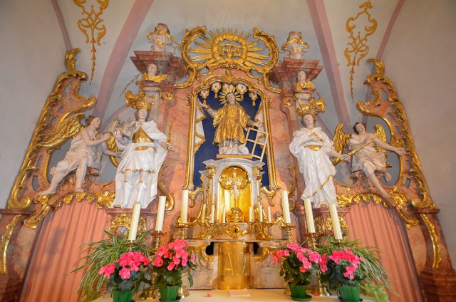Die Schutzpatrone der Kirche sind der heilige Diakon Laurentius von Rom (Patrozinium am 10. August) und der heilige Kaiser Heinrich II. (Patrozinium am 15. Juli). Der Heilige Heinrich hält in seiner rechten Hand ein Modell des Bamberger Doms (l.) - ein Hinweis auf die Zugehörigkeit der Kirche zum Bistum Bamberg. Der Heilige Laurentius (Mitte) hält in seiner Hand einen Rost als Attribut seines Martyriums, denn Laurentius wurde der Überlieferung nach durch Verbrennen auf einem eisernen Rost hingerichtet. | Foto: Nicole Fuchsbauer