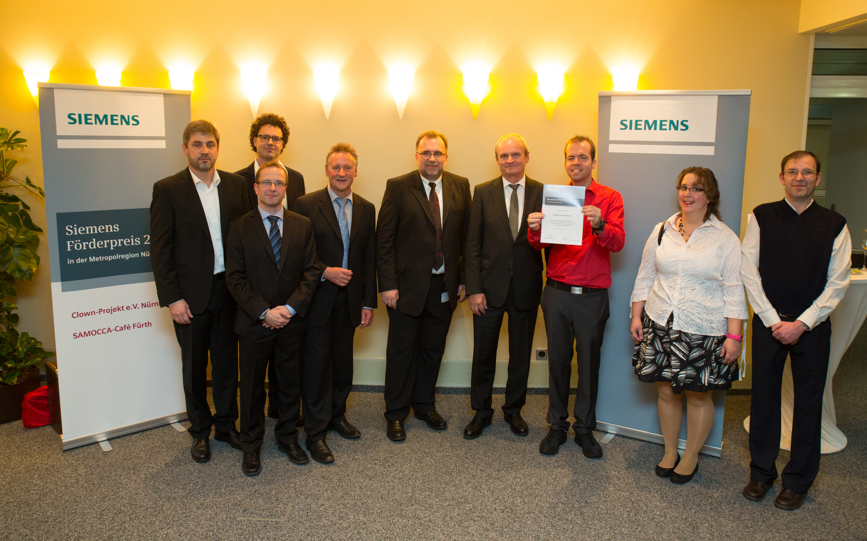 Strahlende Gesichter bei der Preisübergabe: (v.li.n.re.) Rolf Bidner (Geschäftsführer der Dambacher Werkstätten), Kaffeehausleiter Markus Reith, Nils Ortlieb (Lebenshilfe Fürth), Lebenshilfe-Vorsitzender Thomas Jung, Siemens-Vorstand Prof. Siegfried Russwurm, Heinz Brenner (Leitung Siemens Regionalreferat) sowie Stefan Schweidler, Lisa Dahlmann und Klaus Schmid, Mitarbeiter im Samocca.