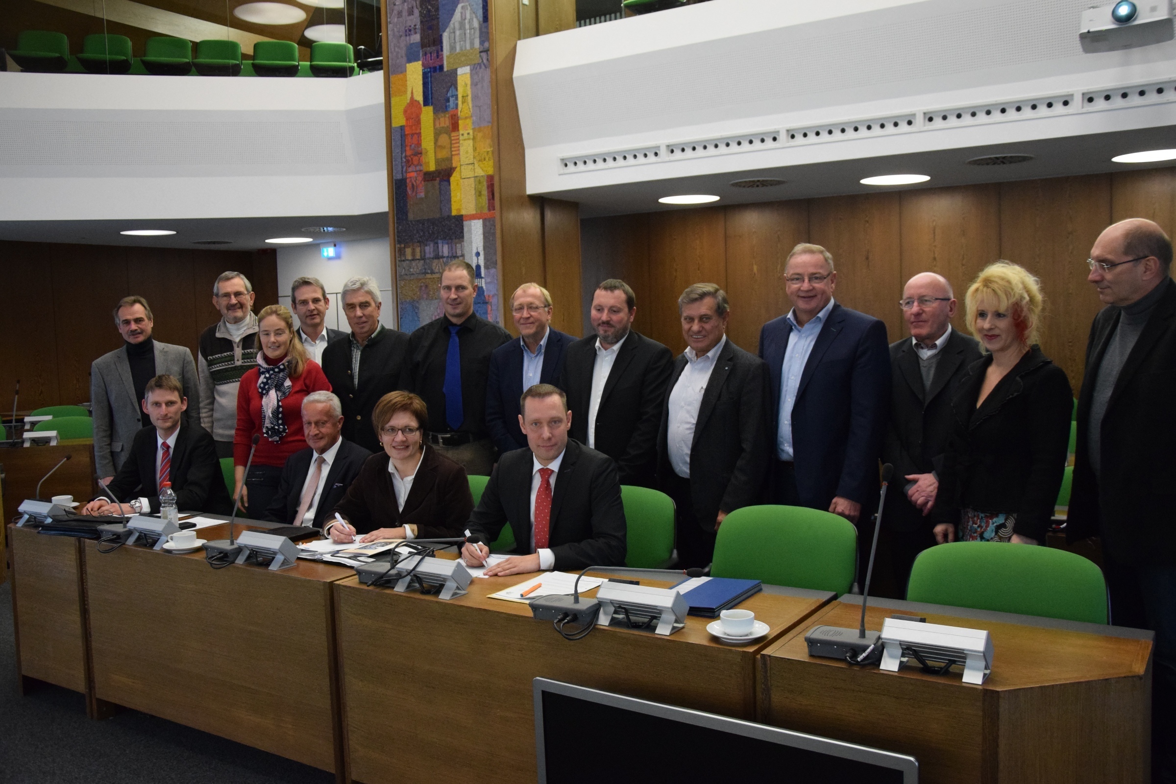 Landrat Armin Kroder und Claudia Lehnerer, Projektleiterin der Transferagentur in der Metropolregion, unterzeichnen die Zielvereinbarung im Beisein der Mitglieder des Ausschusses für Kreisentwicklung.