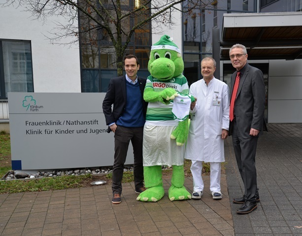 Zusammen mit dem Kleeblatt-Maskottchen Eddy stellten Timo Schiller, Leiter Marketing, Vertrieb & Kommunikation bei der SpVgg Greuther Fürth, Chefarzt Prof. Dr. med. Volker Hanf und Klinikums-Vorstand Peter Krappmann (v.li.n.re.) das „Neugeborenen-Paket“ der Spielvereinigung vor.