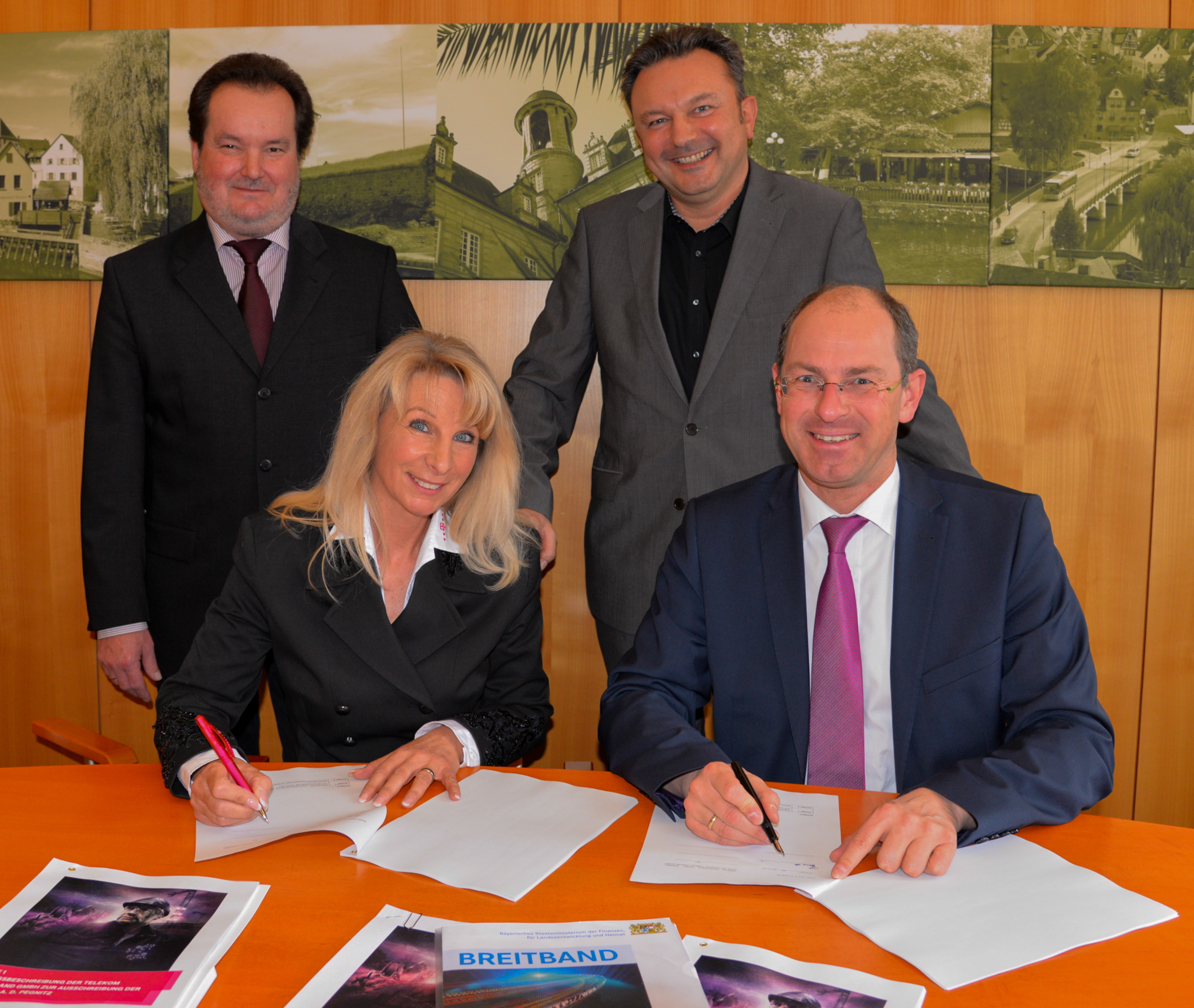 Im Beisein von Uwe Zwick aus dem Fachgebiet Wirtschaftsförderung und Stadtentwicklung (2.v.r.) und Bernd Kohlbauer (l.) unterzeichneten Marion Thüngen (Telekom) und Bürgermeister Benedikt Bisping den Kooperationsvertrag.