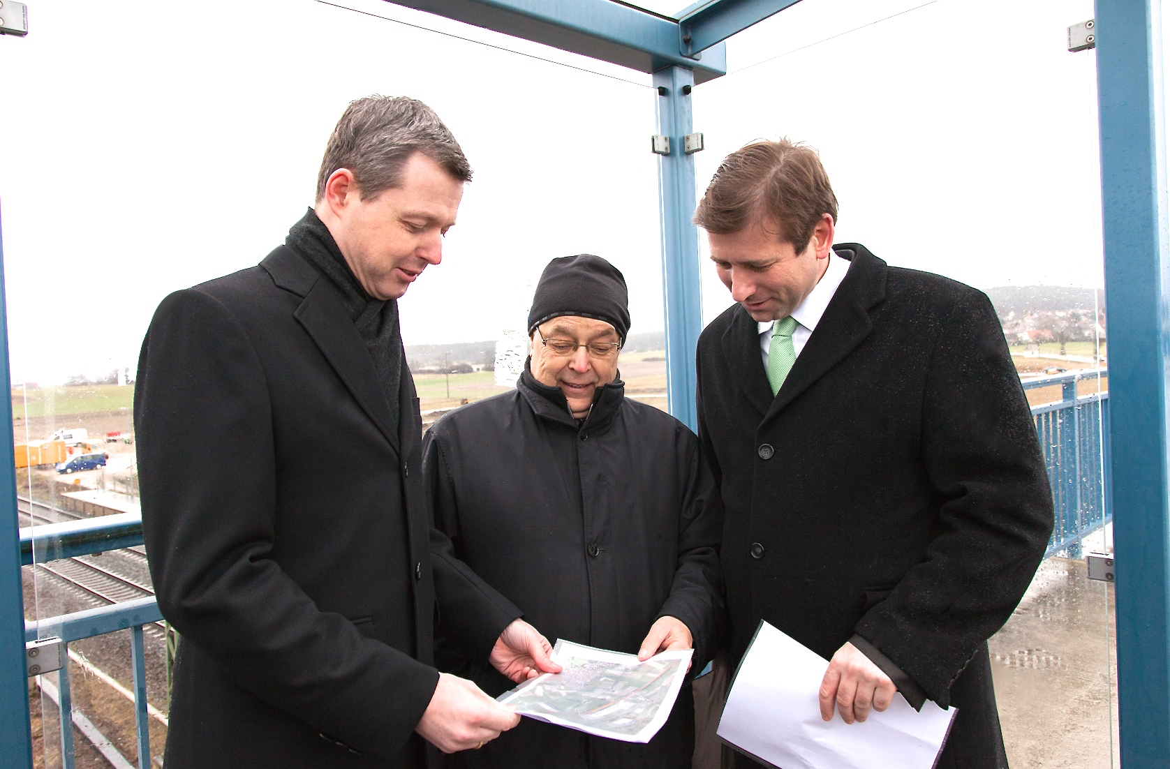 Ortstermin im Regen: Thomas Silberhorn MdB, OB Franz Stumpf und Landrat Hermann Ulm (v.l.n.r.) vor dem künftigen Baugebiet Stampfäcker. Foto: Roland Rosenbauer