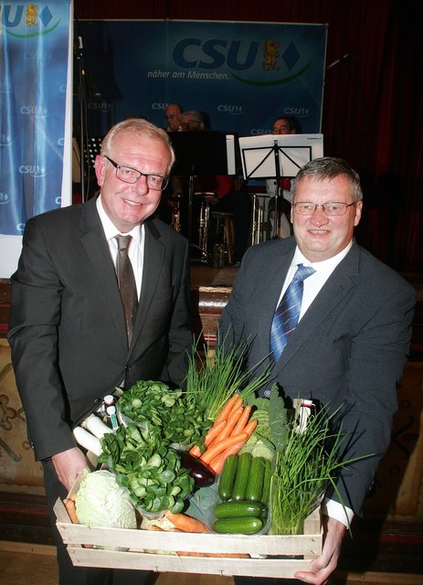 Landwirt Michael Brückner (r.), überreicht Thomas Kreuzer, einen „regionalen Präsentkorb“.