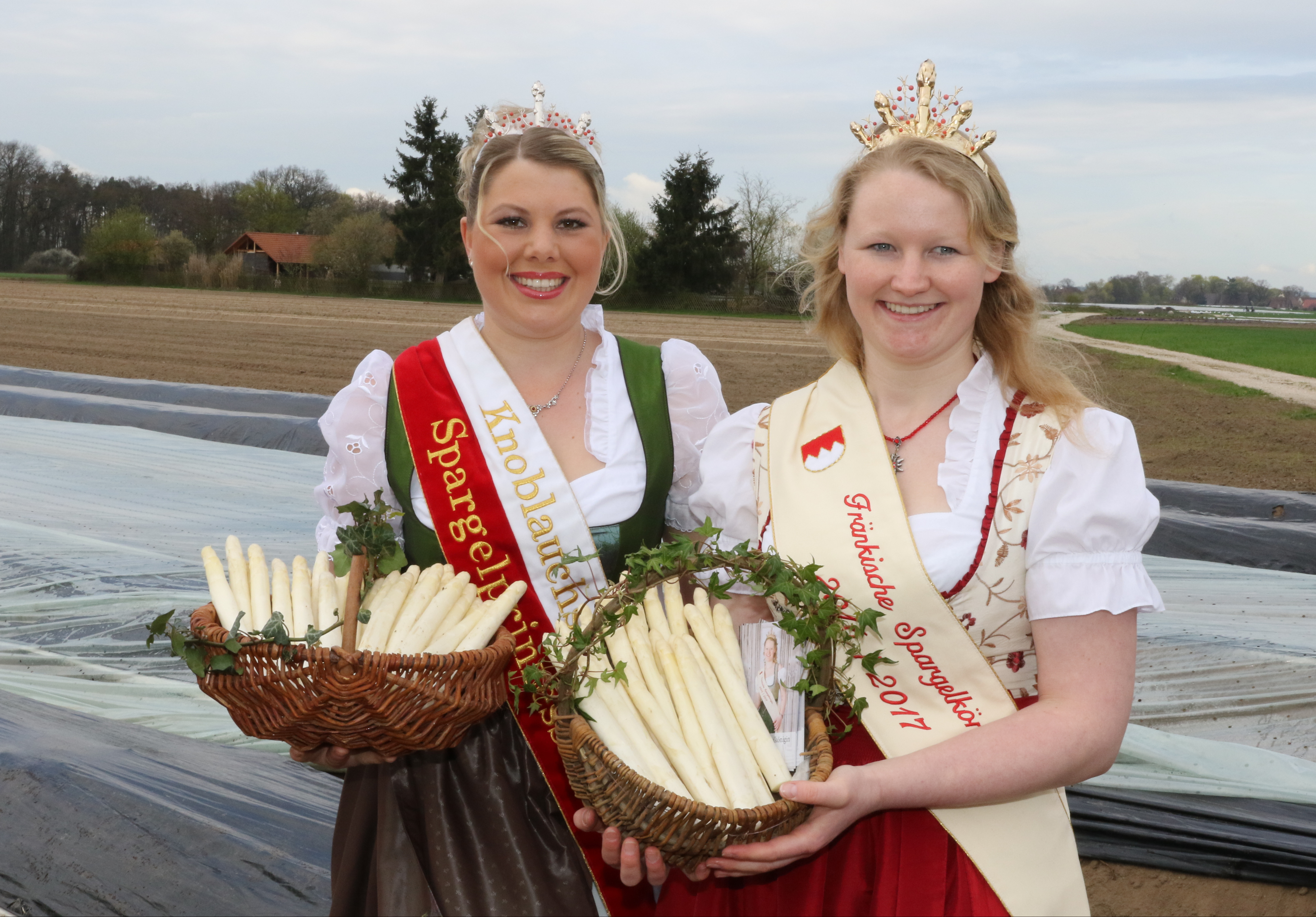 Die Fränkische Spargelkönigin Anna Hennicke (r.) und die Knoblauchsländer Spargelprinzessin Veronika Höffler präsentieren das erste ,,fränkische Gold".