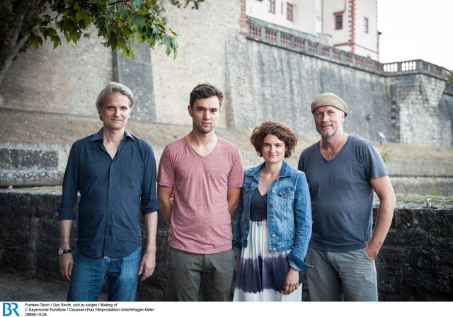 Regisseur Andreas Senn, Nils Strunk (Rolle: Doktorand Philipp) und Eli Wasserscheid (Rolle: Kommissarin Wanda Goldwasser) sowie Kameramann Holly Fink beim Dreh an der Festung Marienberg (v.l.). | Foto: BR/Claussen+Putz Filmproduktion GmbH/Hagen Keller
