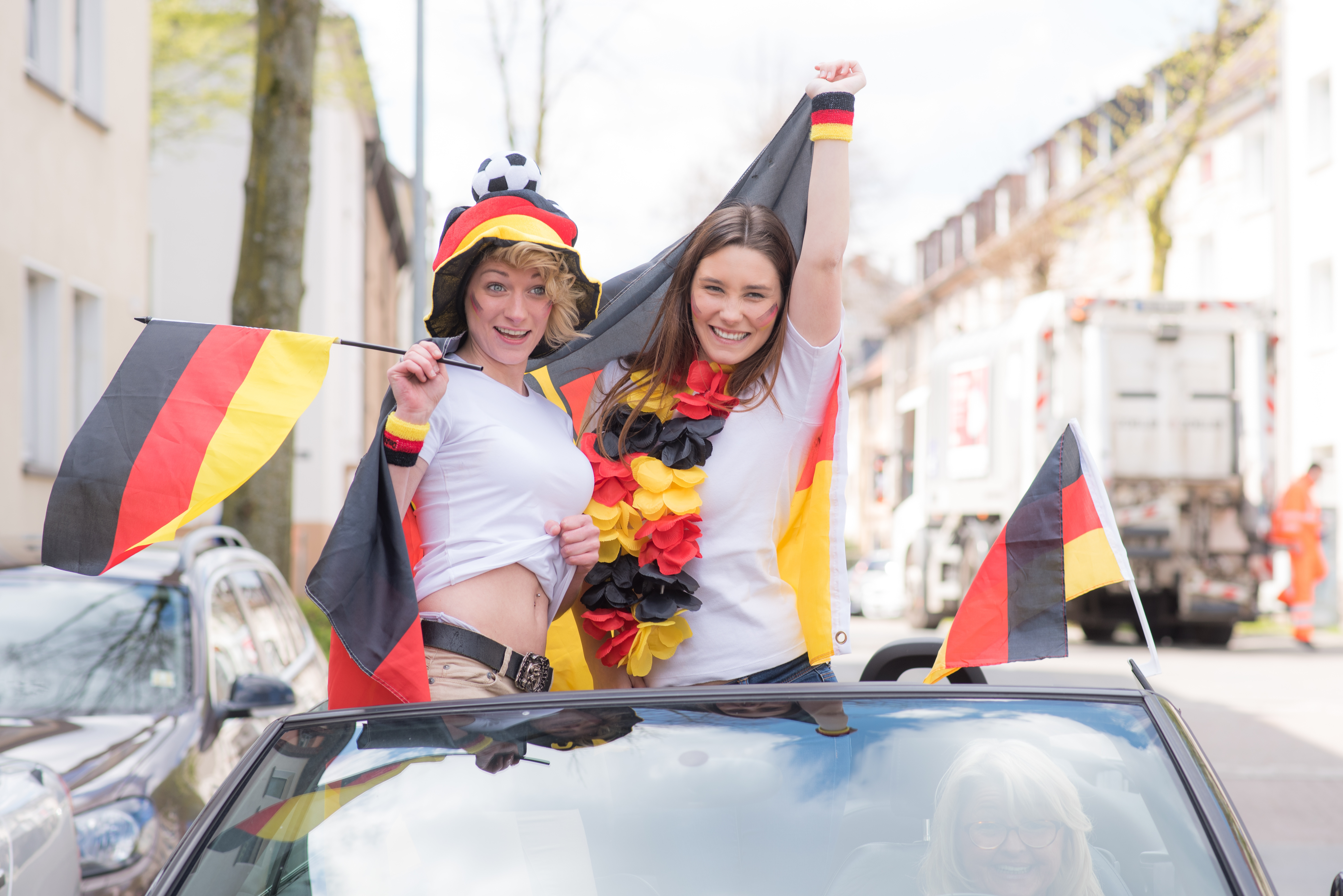 Wer sich während der Fahrt aus Fenstern lehnt oder aus dem Schiebedach Fahnen schwenkt riskiert den Versicherungsschutz.