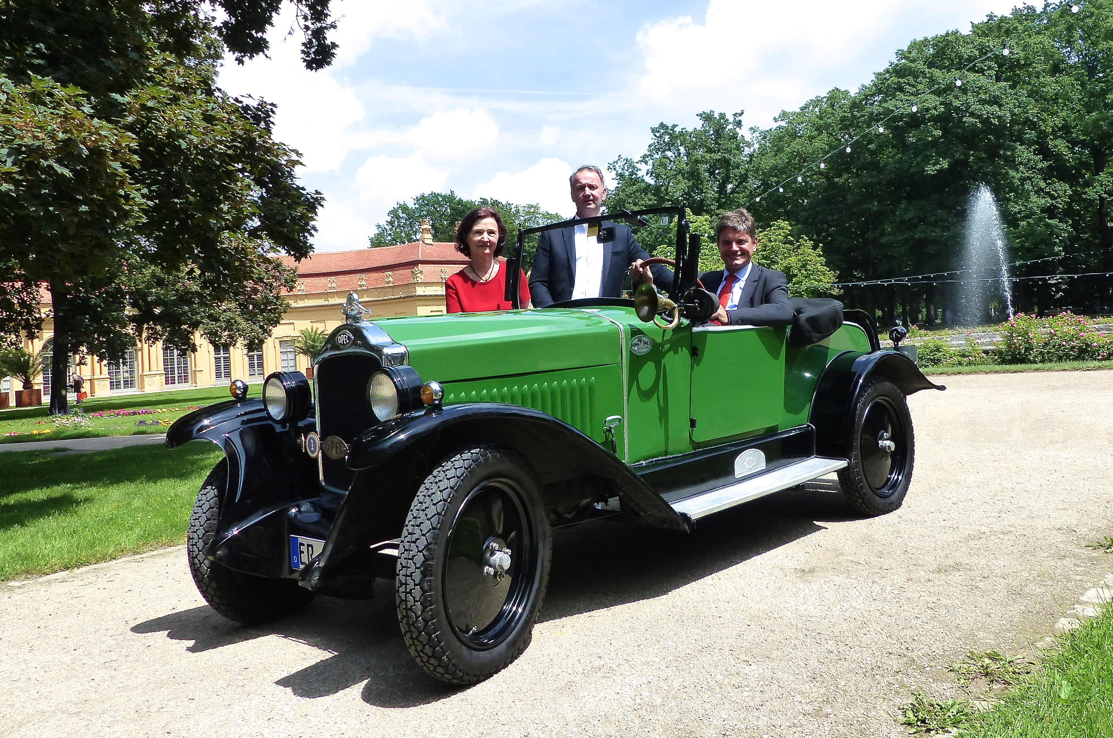 Ursula Ertl, Norbert Nägel und Joachim Hornegger (v.l.n.r.) mit einem Opel 4/16, der im hinteren Teil des Schlossgartens für Rundfahrten zur Verfügung steht. Das Auto stammt aus den 1920er Jahren, hat 16 PS und bringt Spitze 70 km/h – im Schlossgarten wird natürlich langsamer gefahren. Foto: Uwe Müller